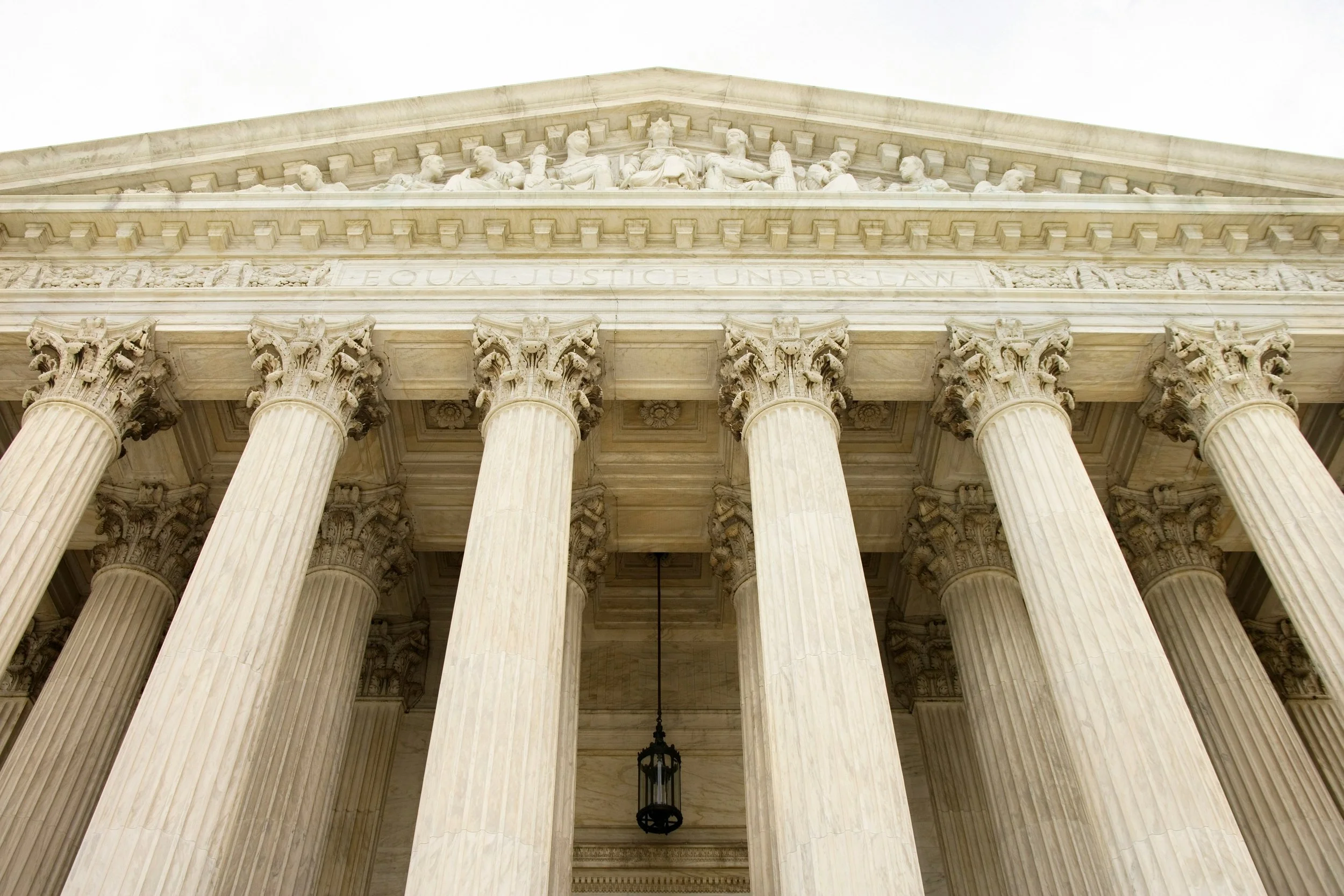 Exterior view of the United States Supreme Court building with marble columns and the inscription Equal Justice Under Law.