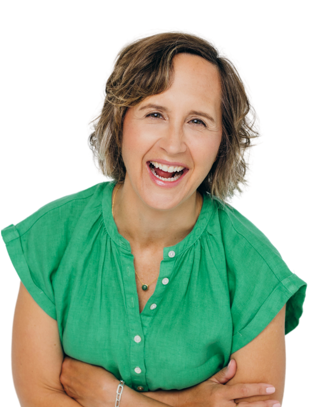 A woman with short, wavy brown hair laughing, wearing a bright green short-sleeved blouse with buttons, standing against a plain white background.