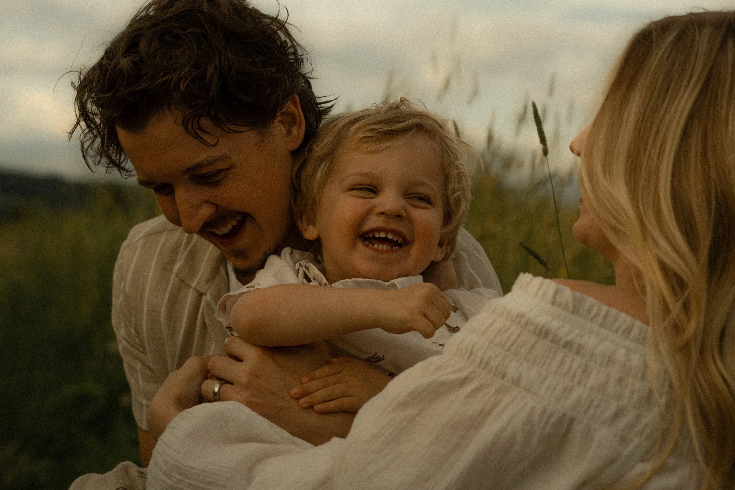 Une famille souriante dehors, garçons et fille, en train de partager un moment joyeux.