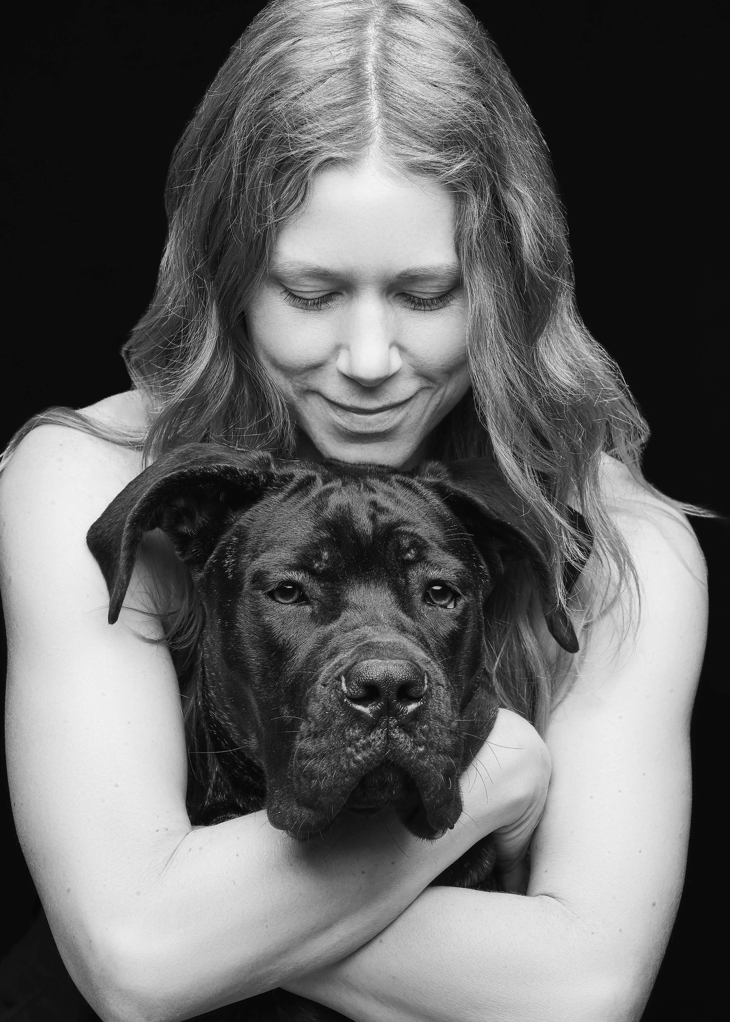 Austin rescue dog photography portrait of a foster mom holding her adopted dog against a black background