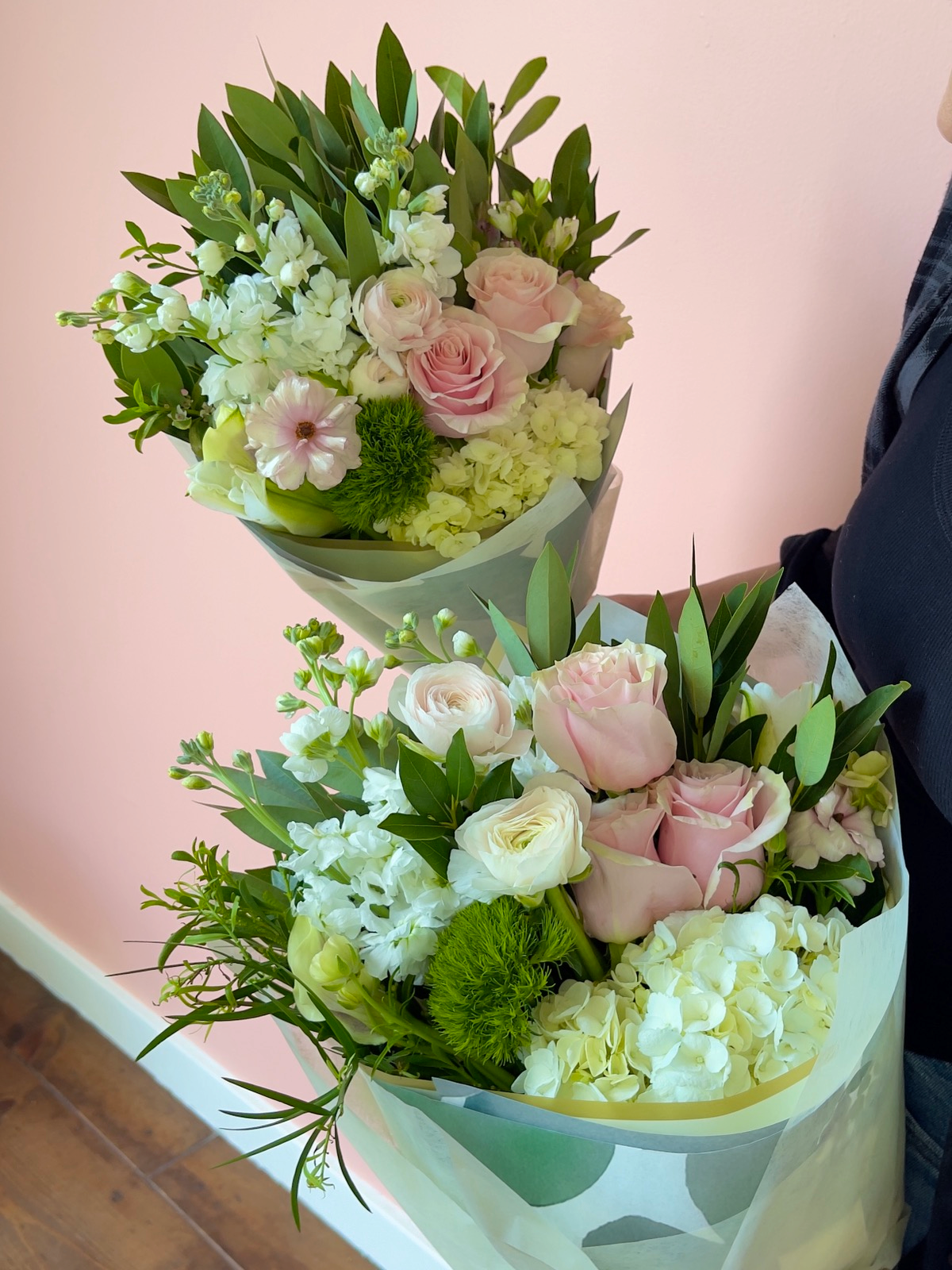 Florist holding Wrapped Bouquets Pink Roses Hydrangea Ranunculus
