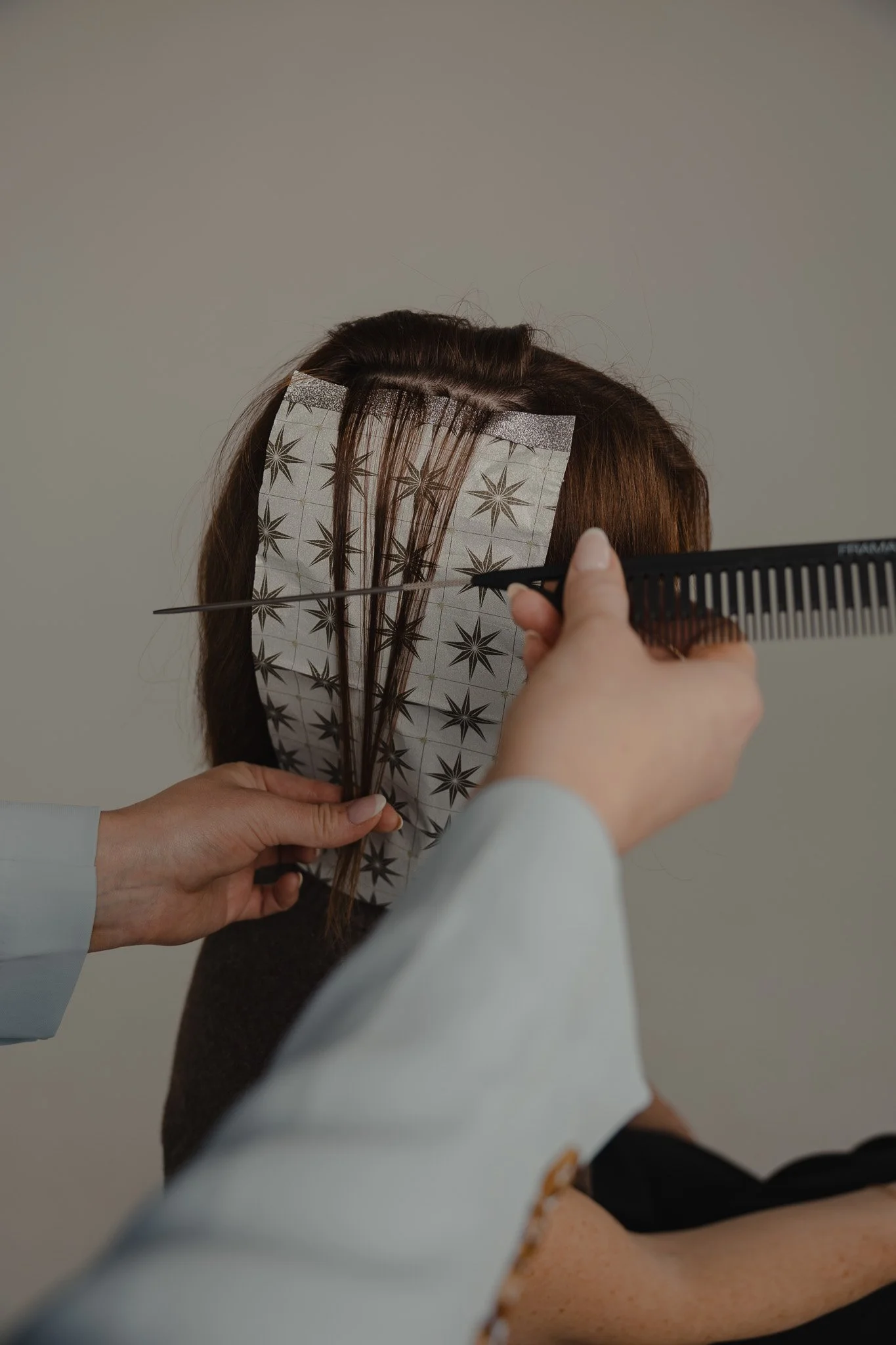Foil highlighting being applied to a client's hair during service