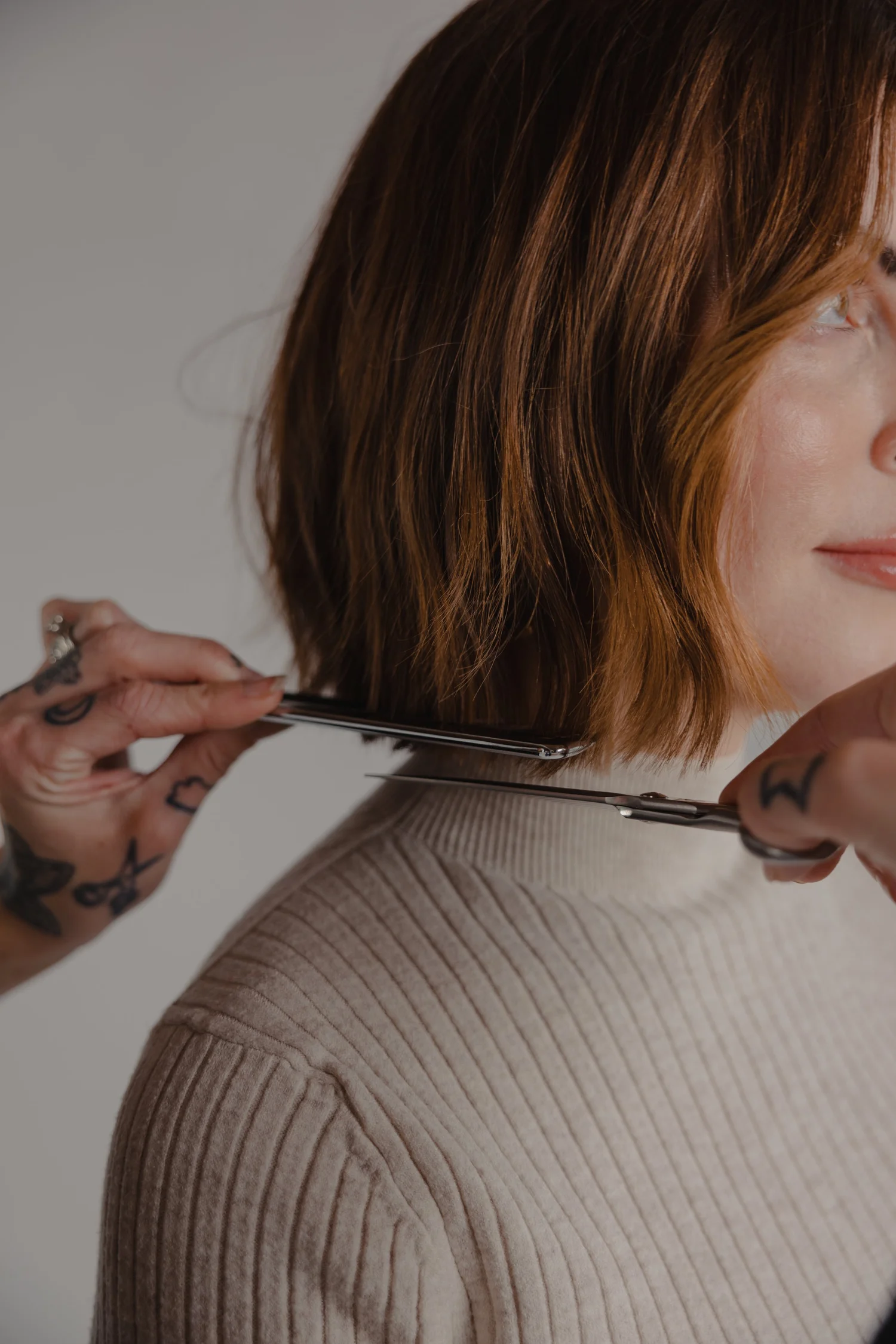 Stylist cutting a client's chin-length bob with scissors