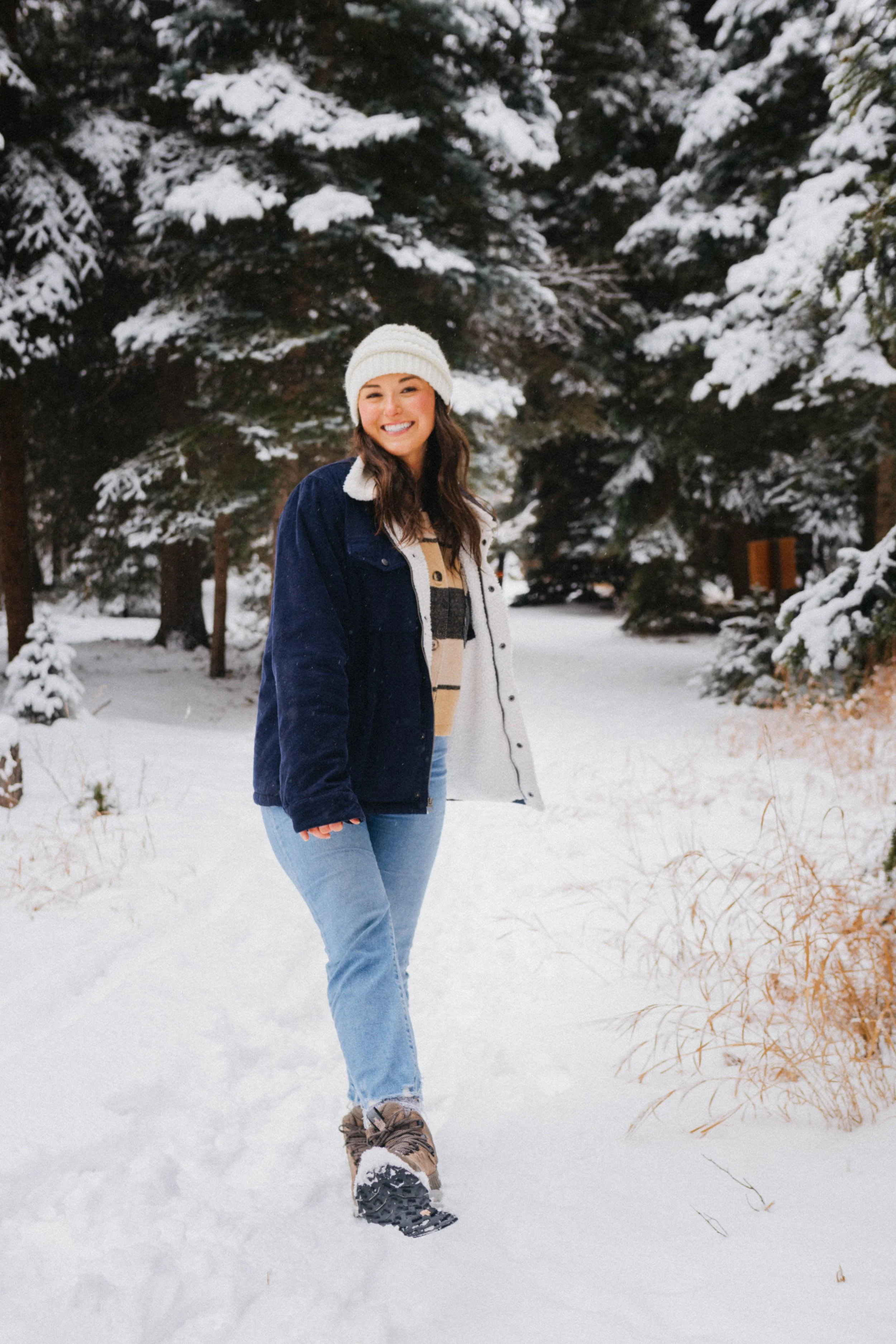 Portrait of girl in winter clothing walking in snowy forest
