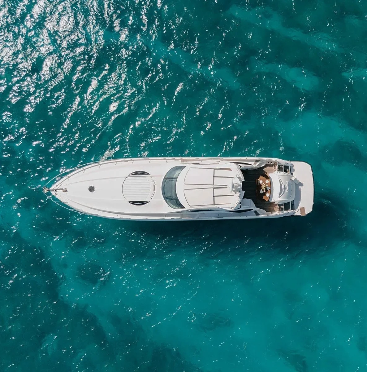 Aerial view of a white yacht on turquoise water