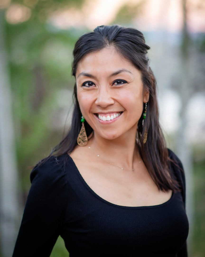 Smiling woman with dark hair and gold earrings