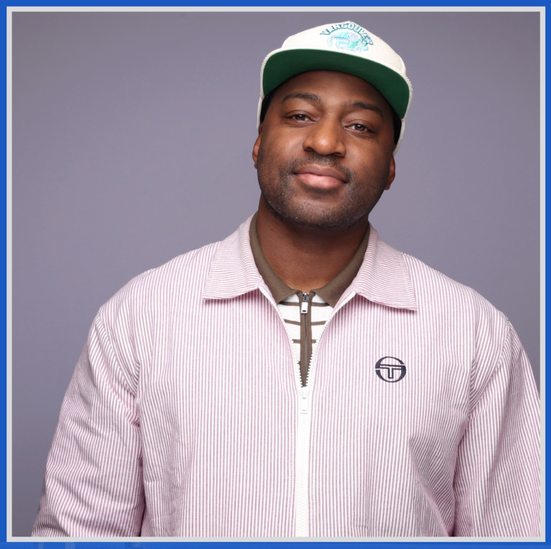 Man in striped jacket and ball cap