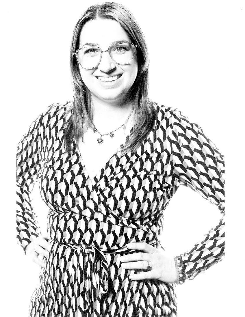 Black and white photo of a woman in a patterned dress.