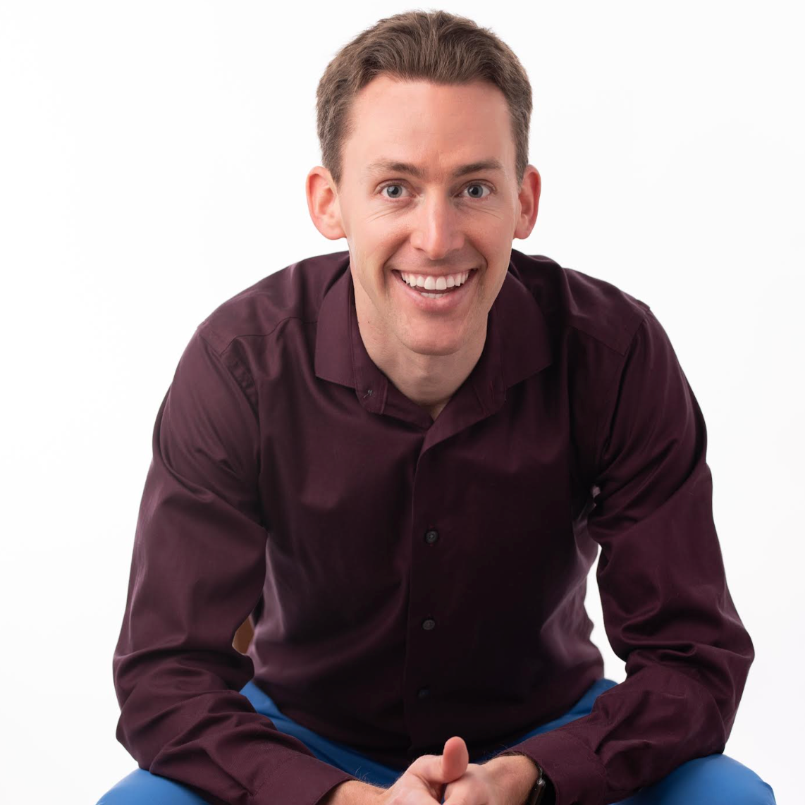 White man wearing a maroon button down shirt