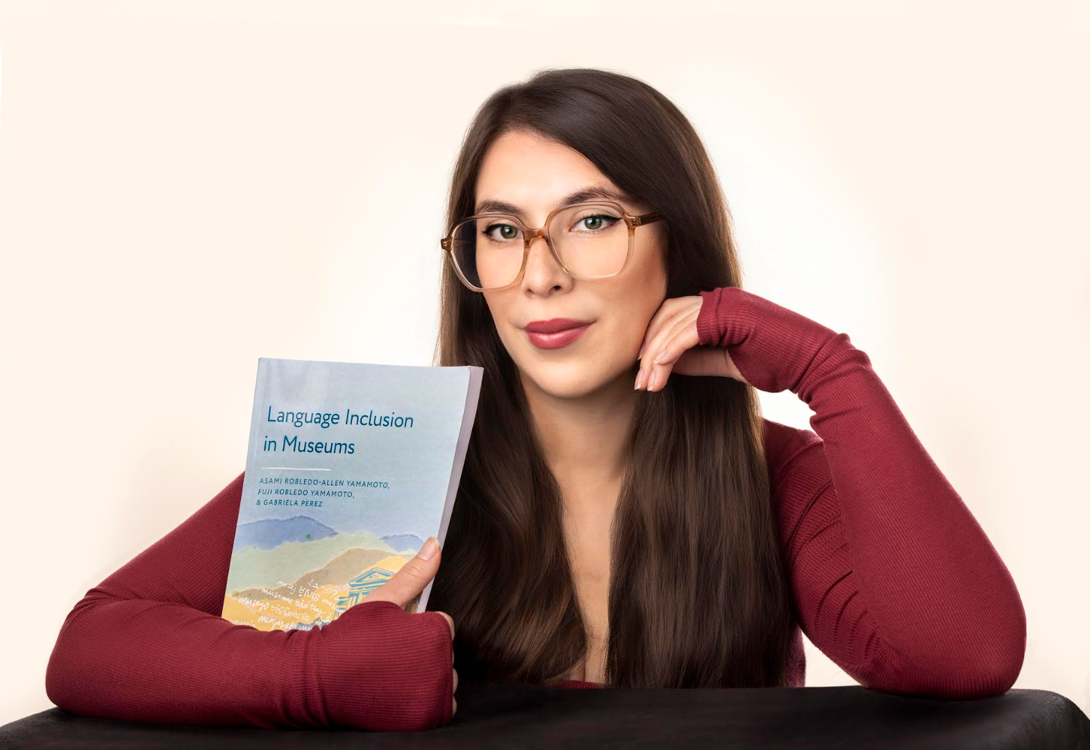 Person holding a book about language inclusion in museums
