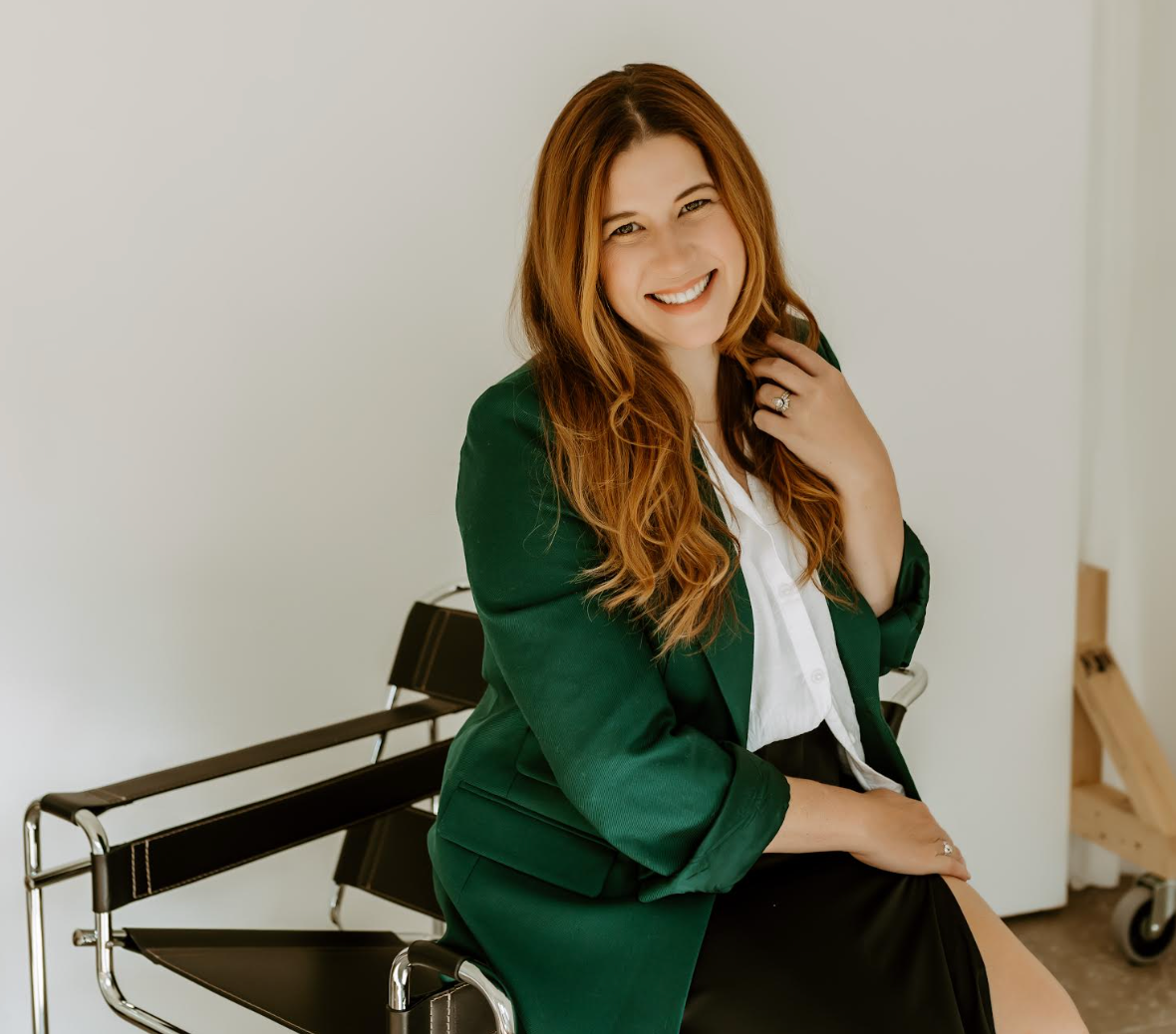 Smiling woman wearing green blazer.