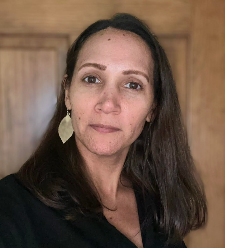 Dark haired woman with gold leaf-shaped earrings.