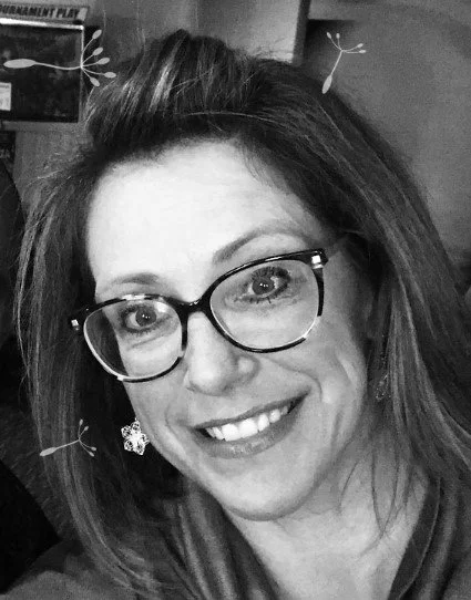 A woman with glasses smiling at the camera, with a cartoonish drone or flying insect graphic overlay.