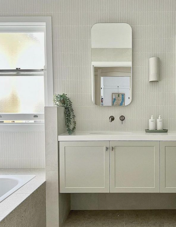 Modern bathroom vanity with white cabinetry, wall-mounted tapware, mirrored cabinet and textured feature tiles in a Mount Hawthorn bathroom renovation.