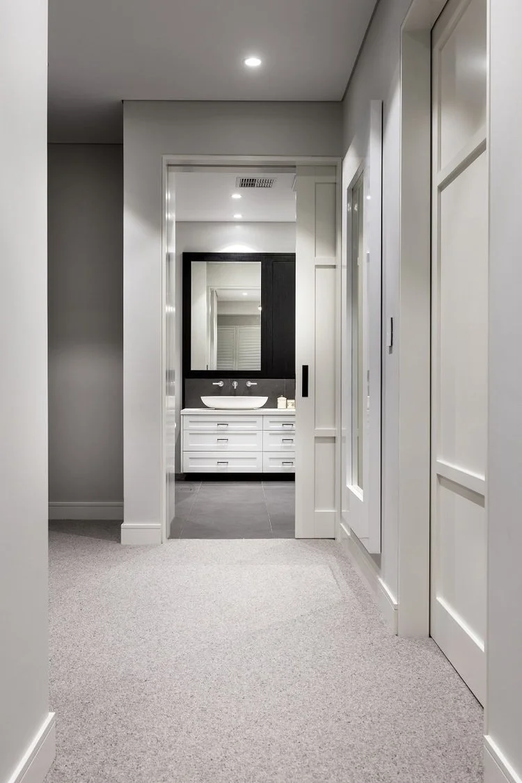 Hallway view into ensuite with white vanity and dark feature wall — ensuite renovation Perth