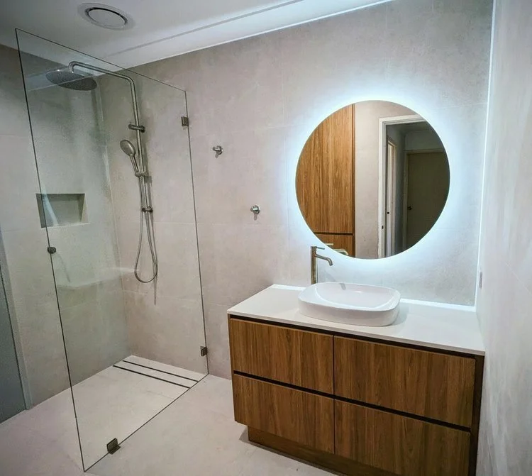 Timber vanity with vessel basin and round LED mirror — bathroom renovation Perth