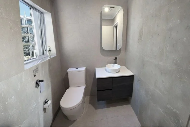 Small bathroom with grey concrete tiles, vessel basin and floating dark vanity — bathroom renovation Perth