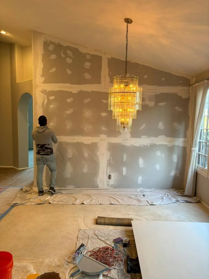 AC Remodeling contractor installing, taping, and mudding sheetrock drywall on a high interior wall in San Diego..jpg
