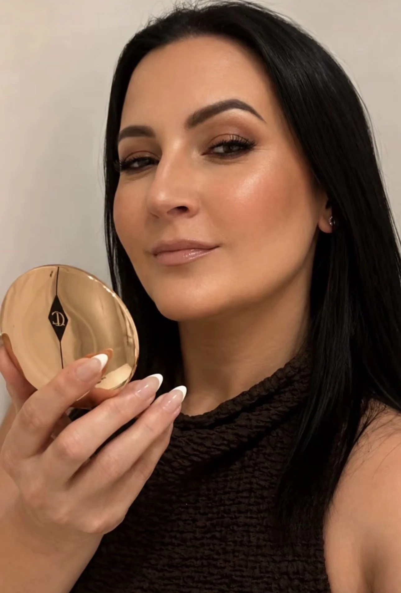 Julia Williams, UGC Creator, holding a Charlotte Tilbury makeup compact.