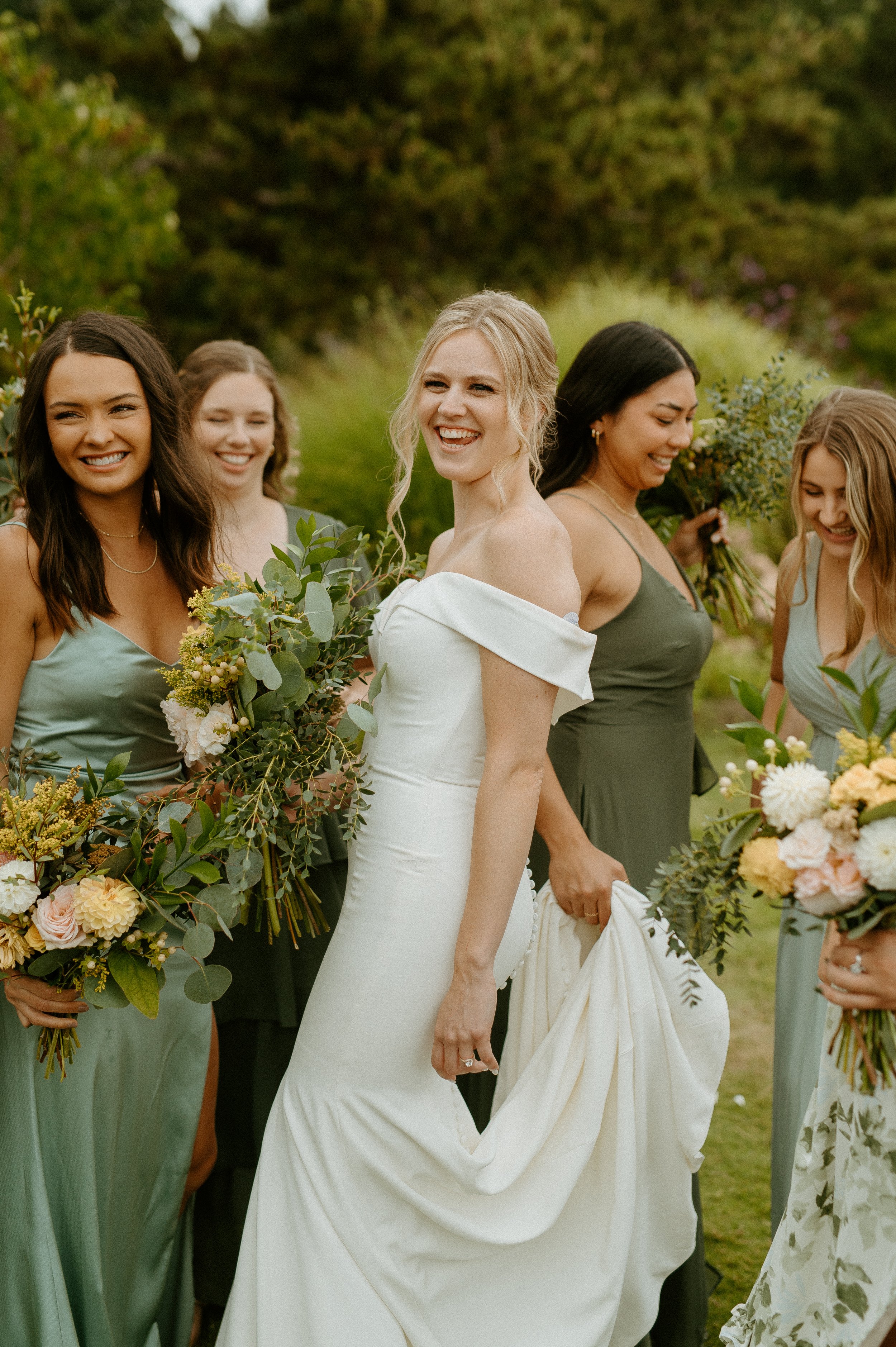 Bride with bridesmaids in sage green dresses holding bouquets + garden wedding + Washington wedding photographer + PNW wedding