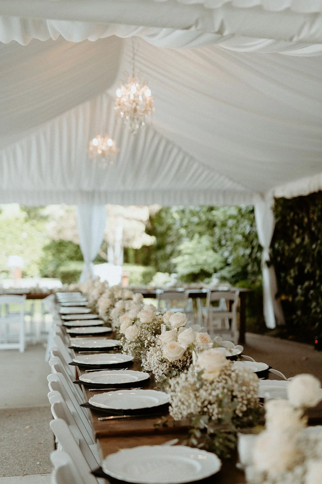 wedding reception + setup + at + The Orting Manor + with + long wooden tables + and + white floral centerpieces + in + Washington