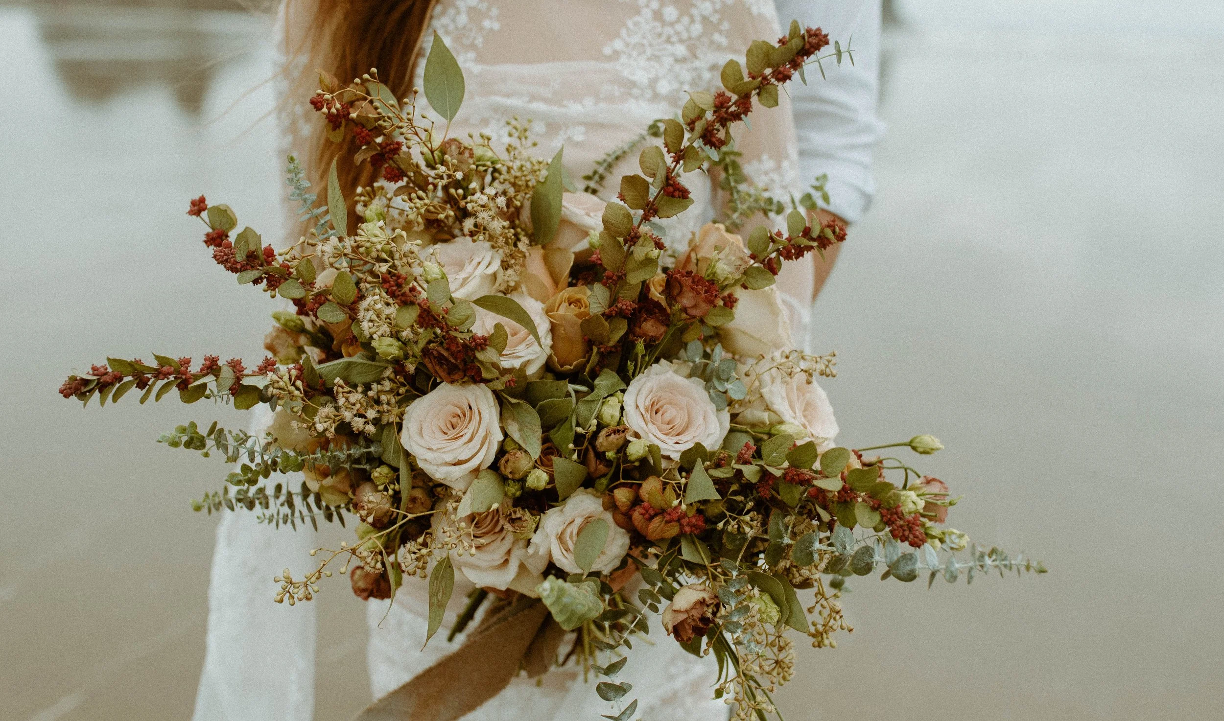 Detailed bridal bouquet with neutral roses and earthy florals photographed on Cannon Beach during an Oregon elopement