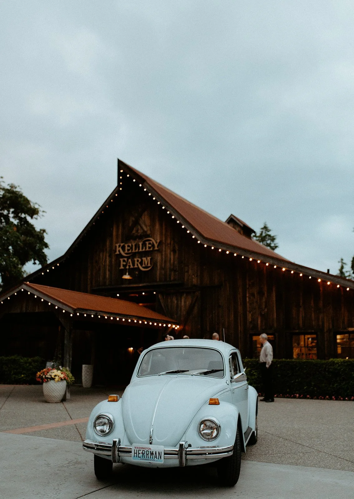 Vintage blue Volkswagen Beetle parked in front of Kelley Farm wedding venue in Buckley Washington