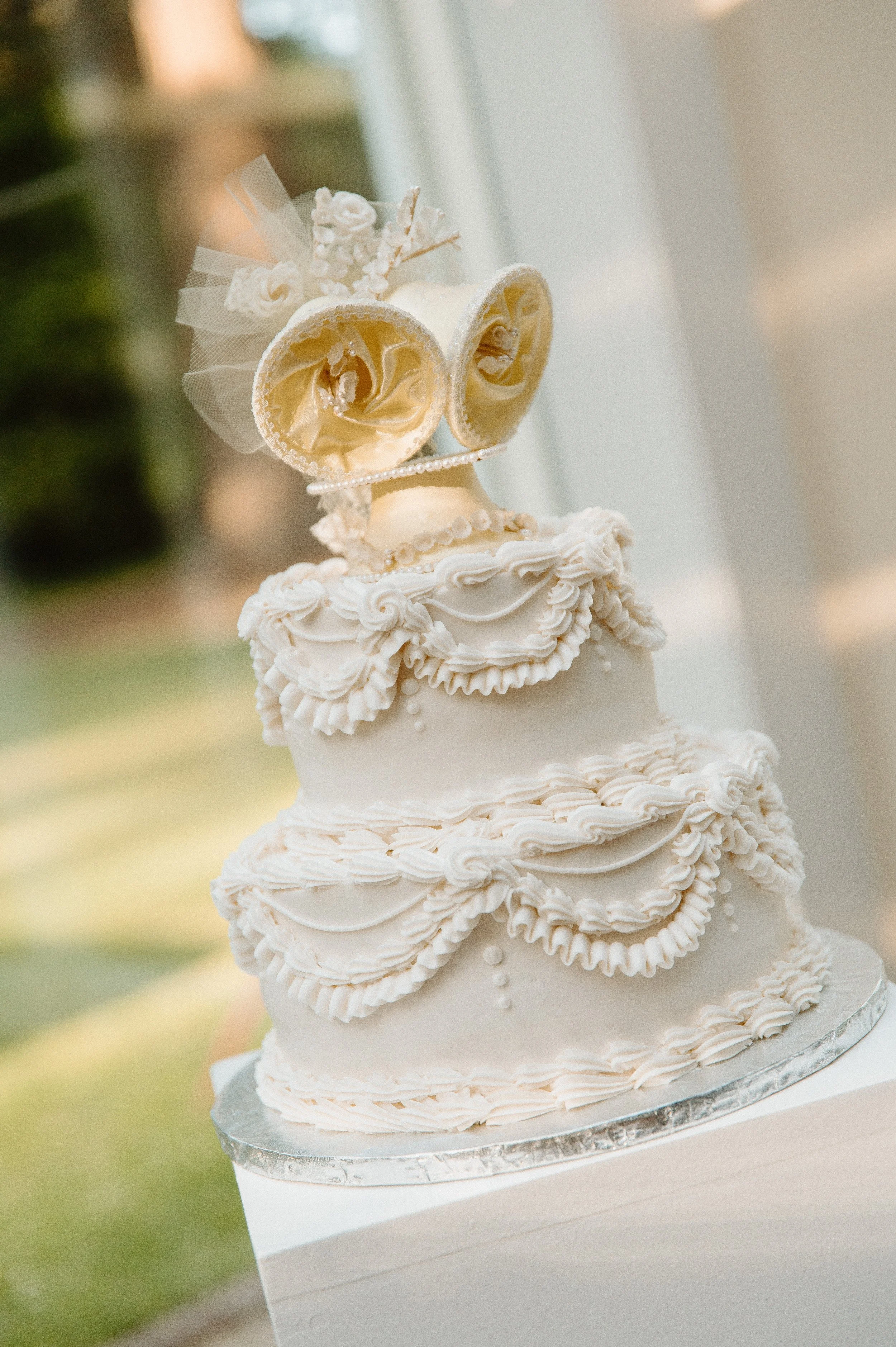 Elegant white wedding cake with vintage-inspired piping at a Lakewold Gardens wedding reception.