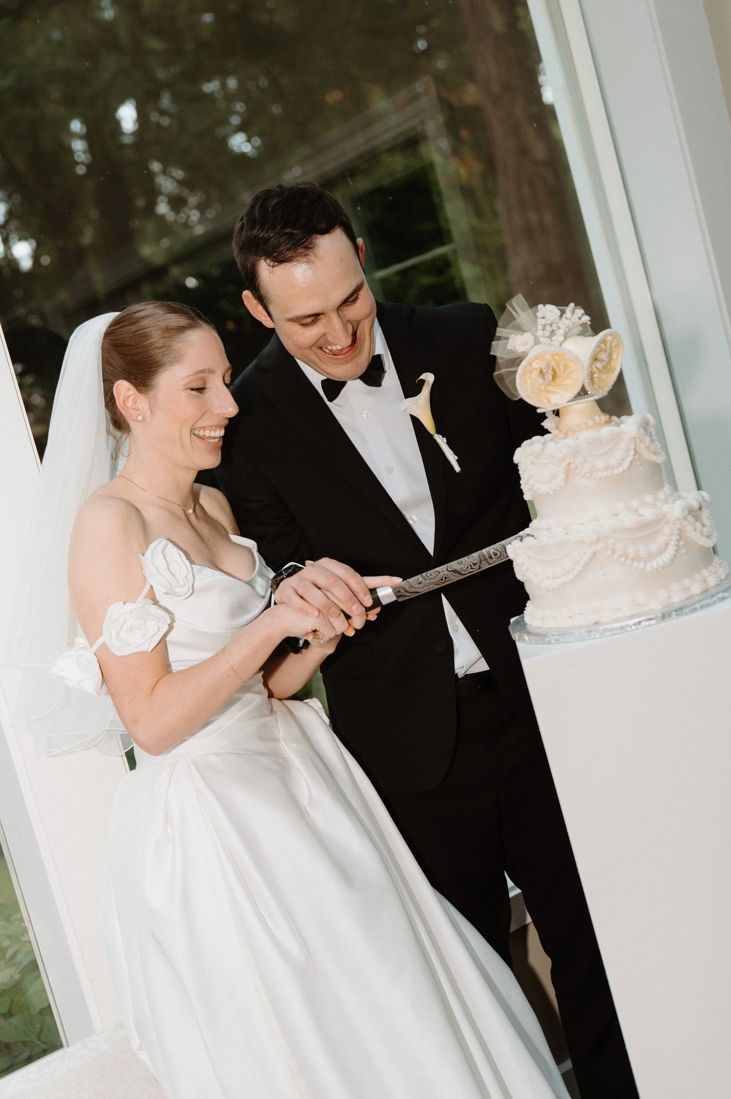     Bride and groom cutting their wedding cake during their Lakewold Gardens wedding reception in Lakewood, Washington.