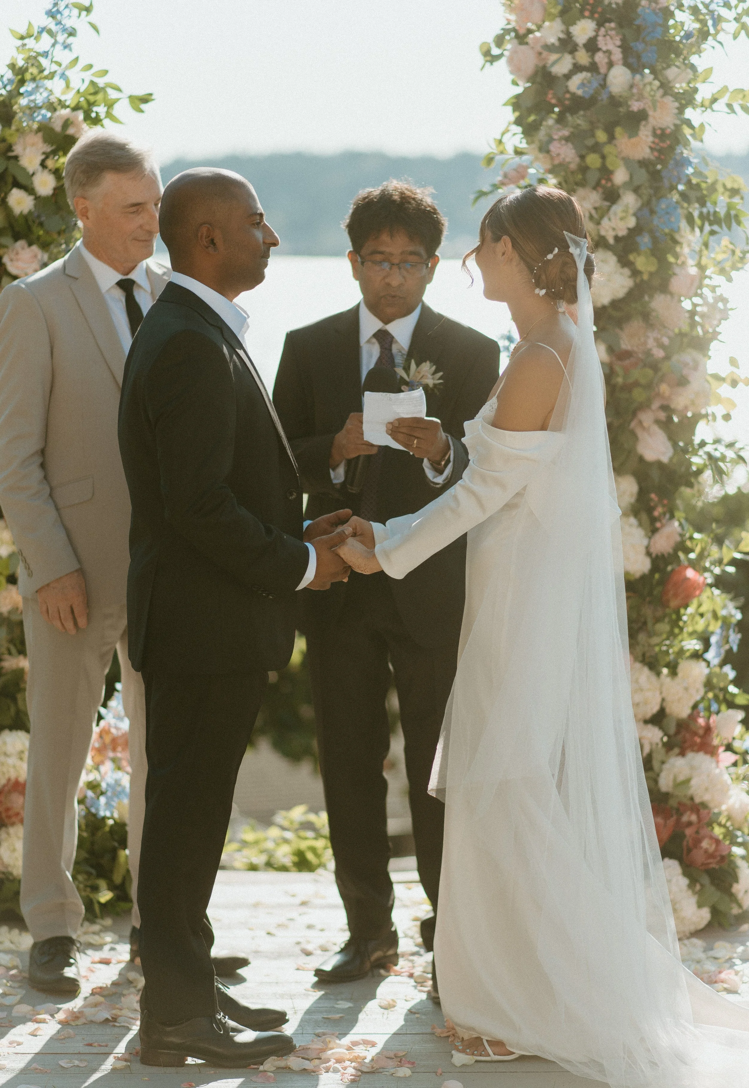 Bride and groom exchanging vows during waterfront backyard wedding ceremony in Seattle