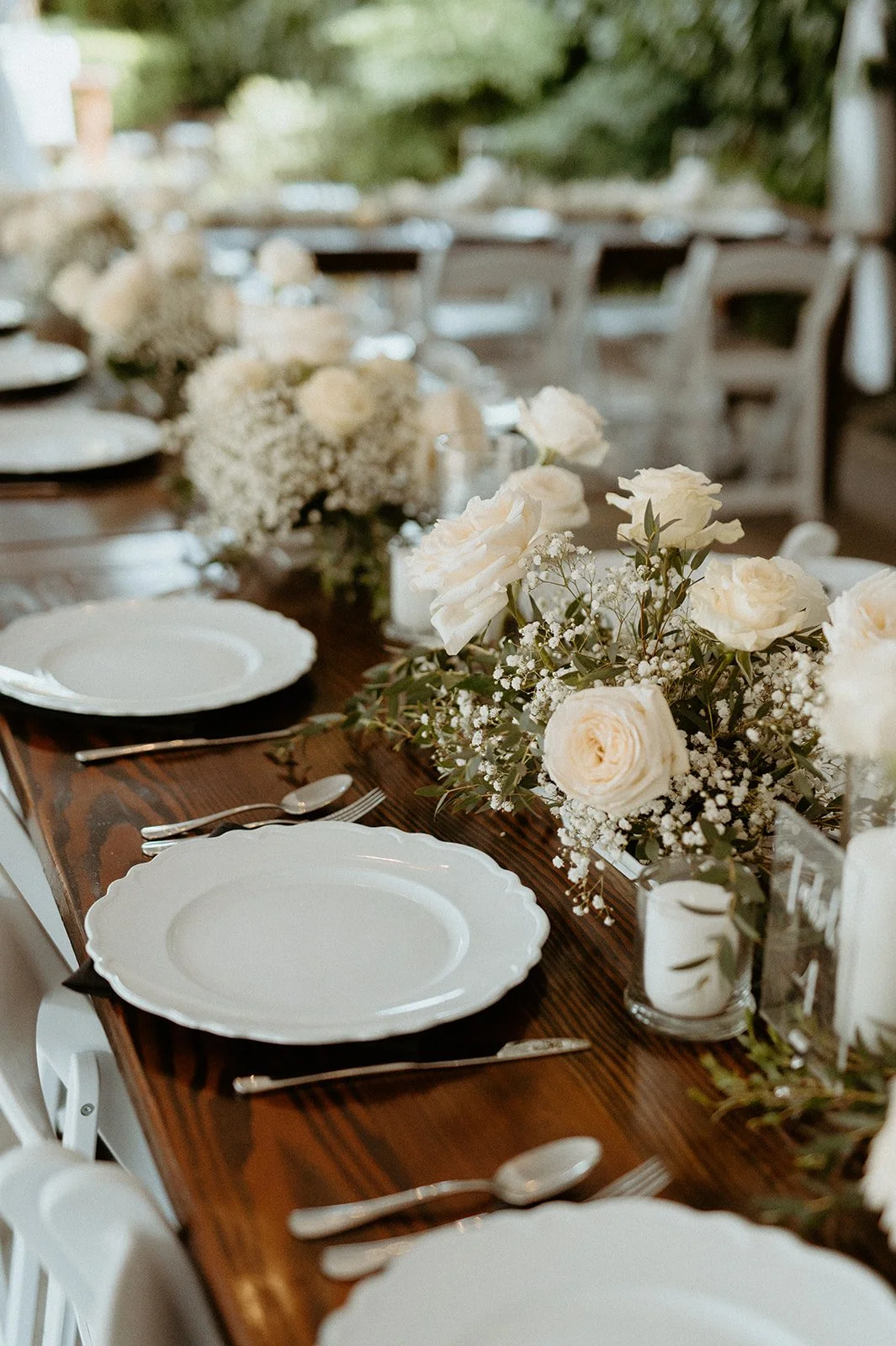 wedding reception table + with + white roses + and + greenery + centerpieces + at + The Orting Manor + in + Orting WA