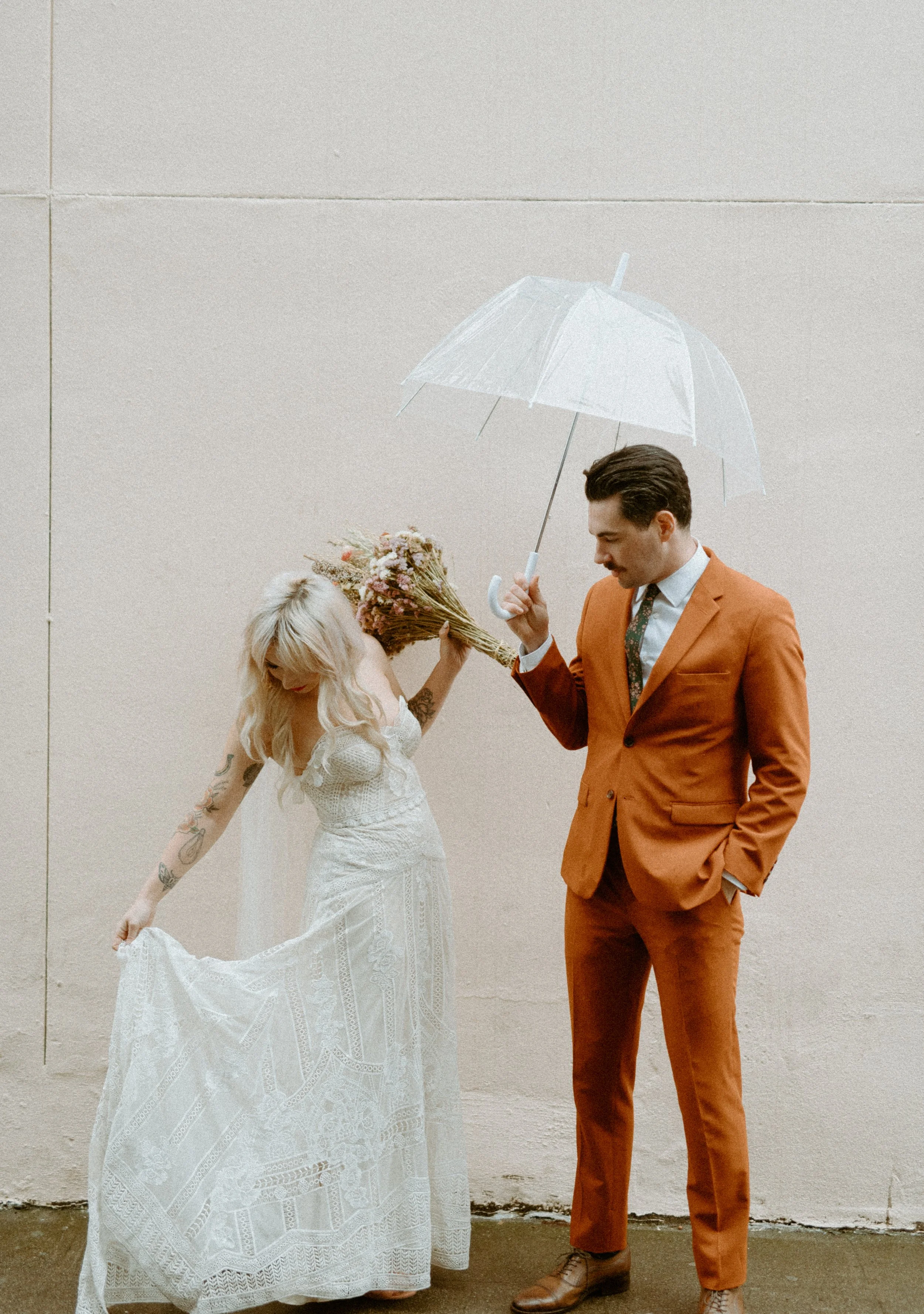 Bride twirling dress while groom holds umbrella during a playful Seattle elopement