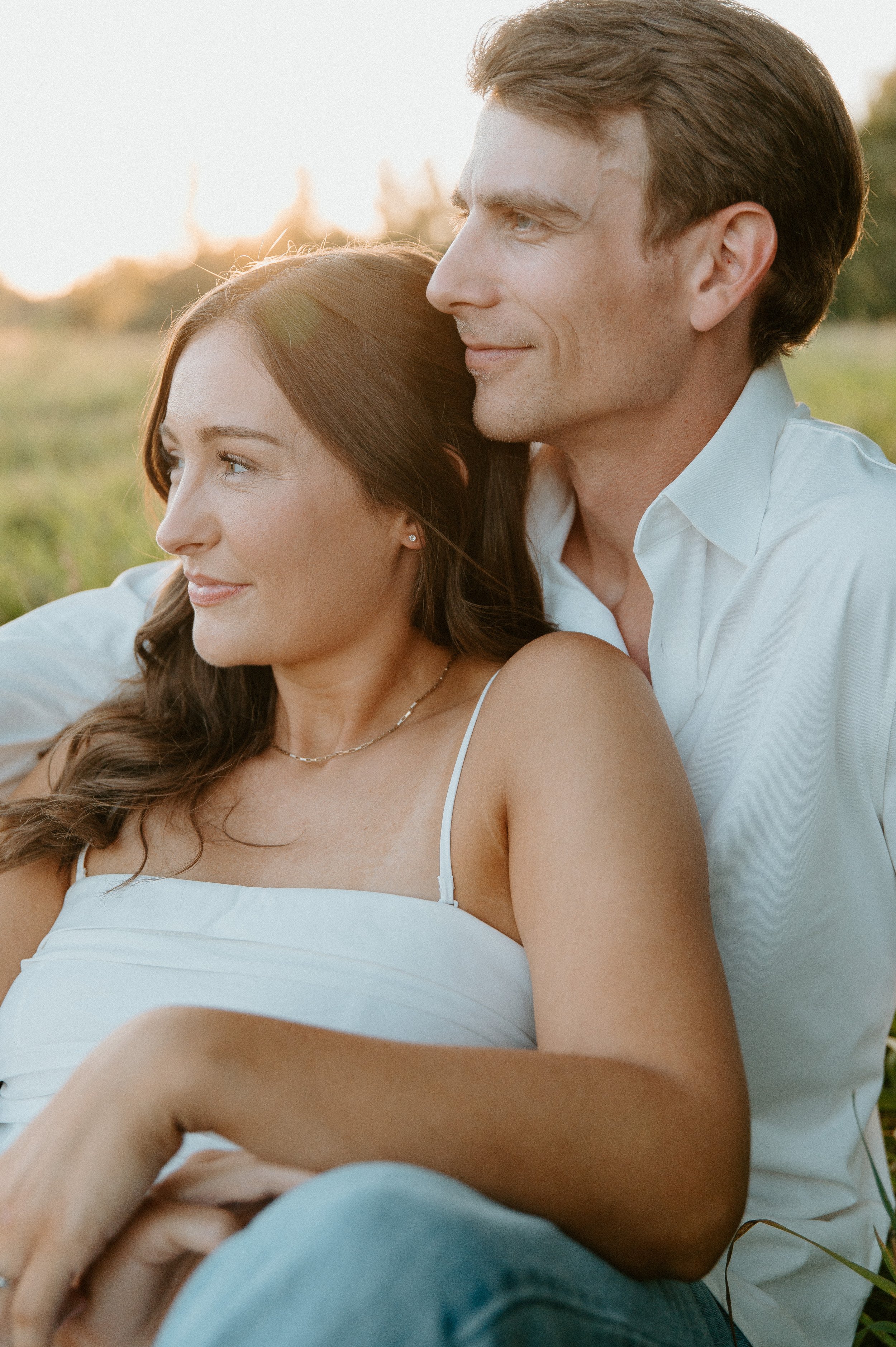 Intimate portrait of an engaged couple sitting together during their golden-hour engagement session