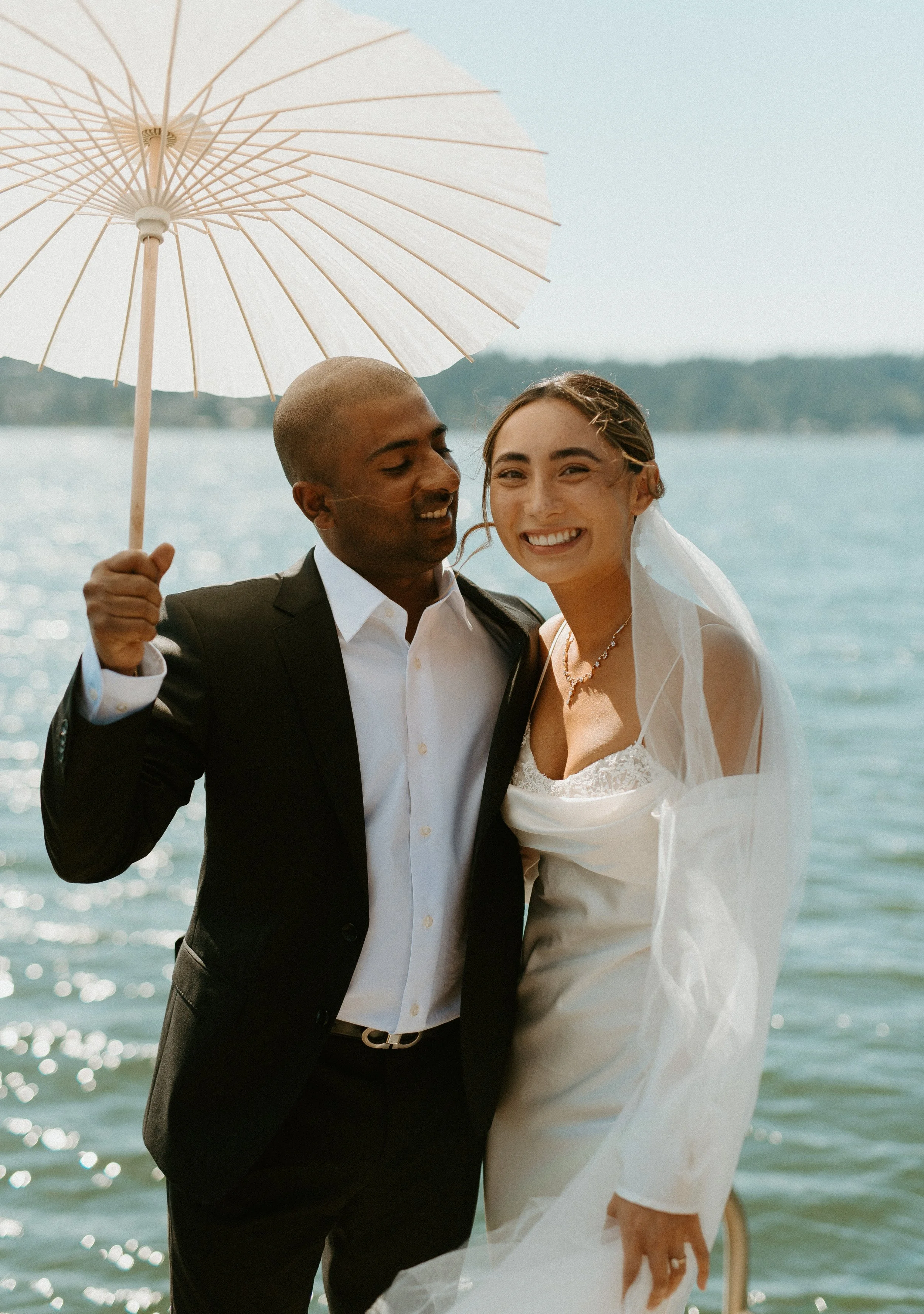 Joyful bride and groom portrait under parasol during cinematic Seattle backyard wedding