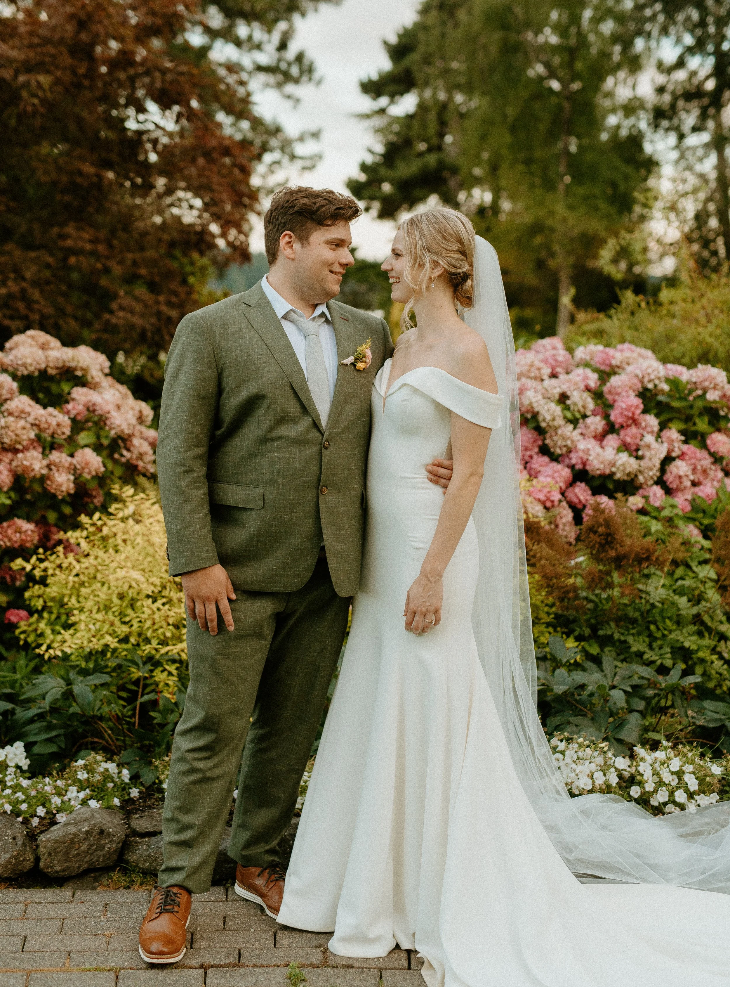 Bride and groom smiling at each other in garden portraits + intimate wedding photography + Washington wedding + PNW wedding photographer