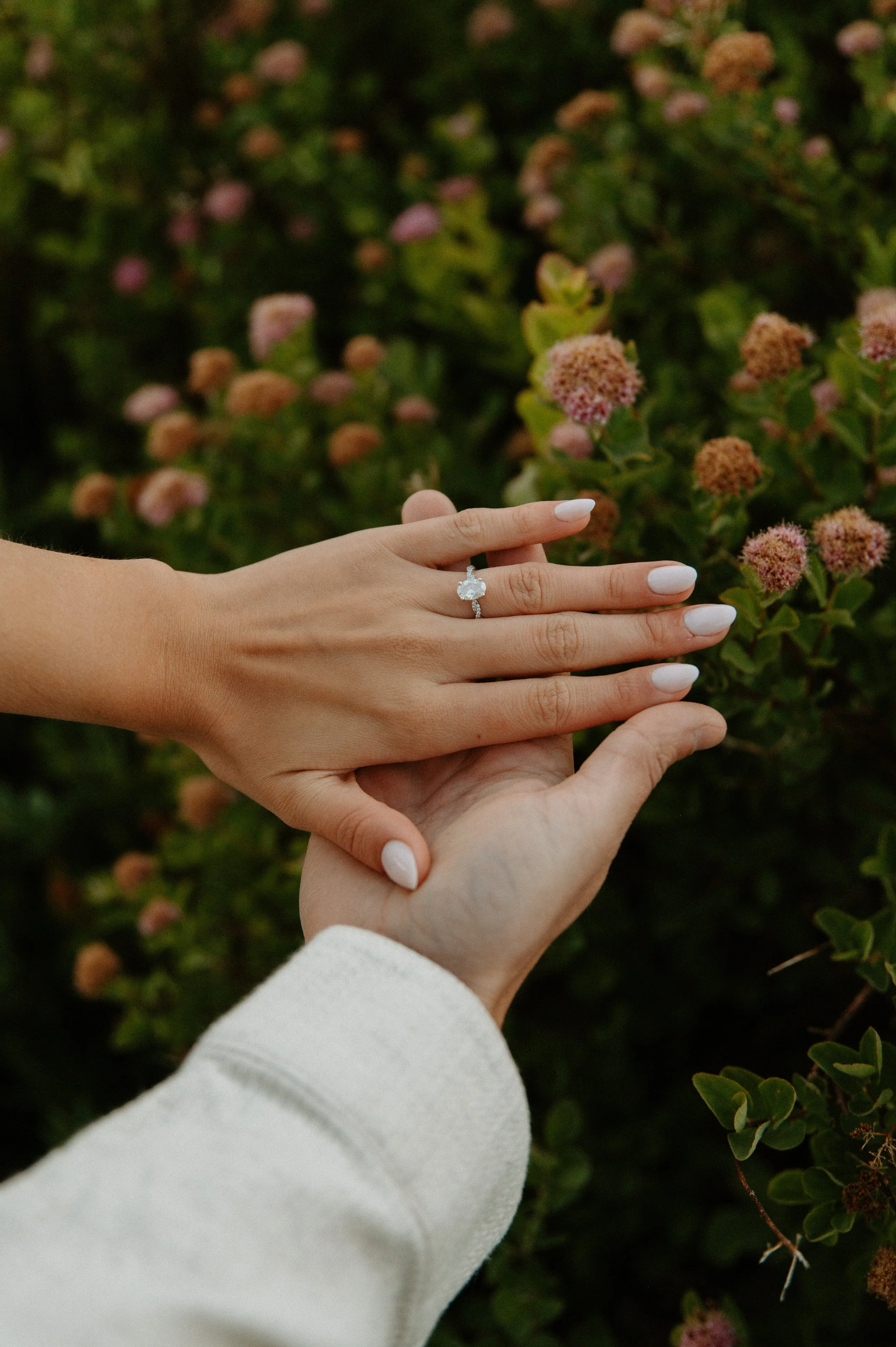Close-up detail of an engagement ring as the couple holds hands during their mountain engagement session.
