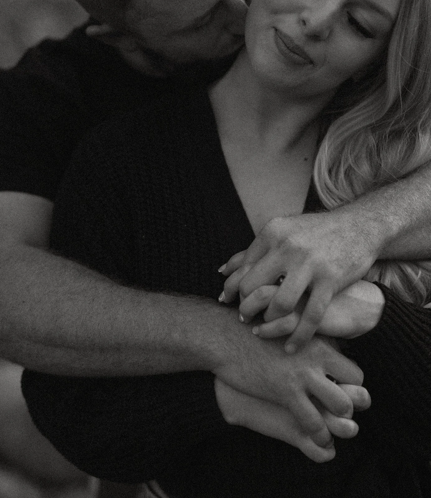 Black and white close-up of couple holding hands in an intimate moment