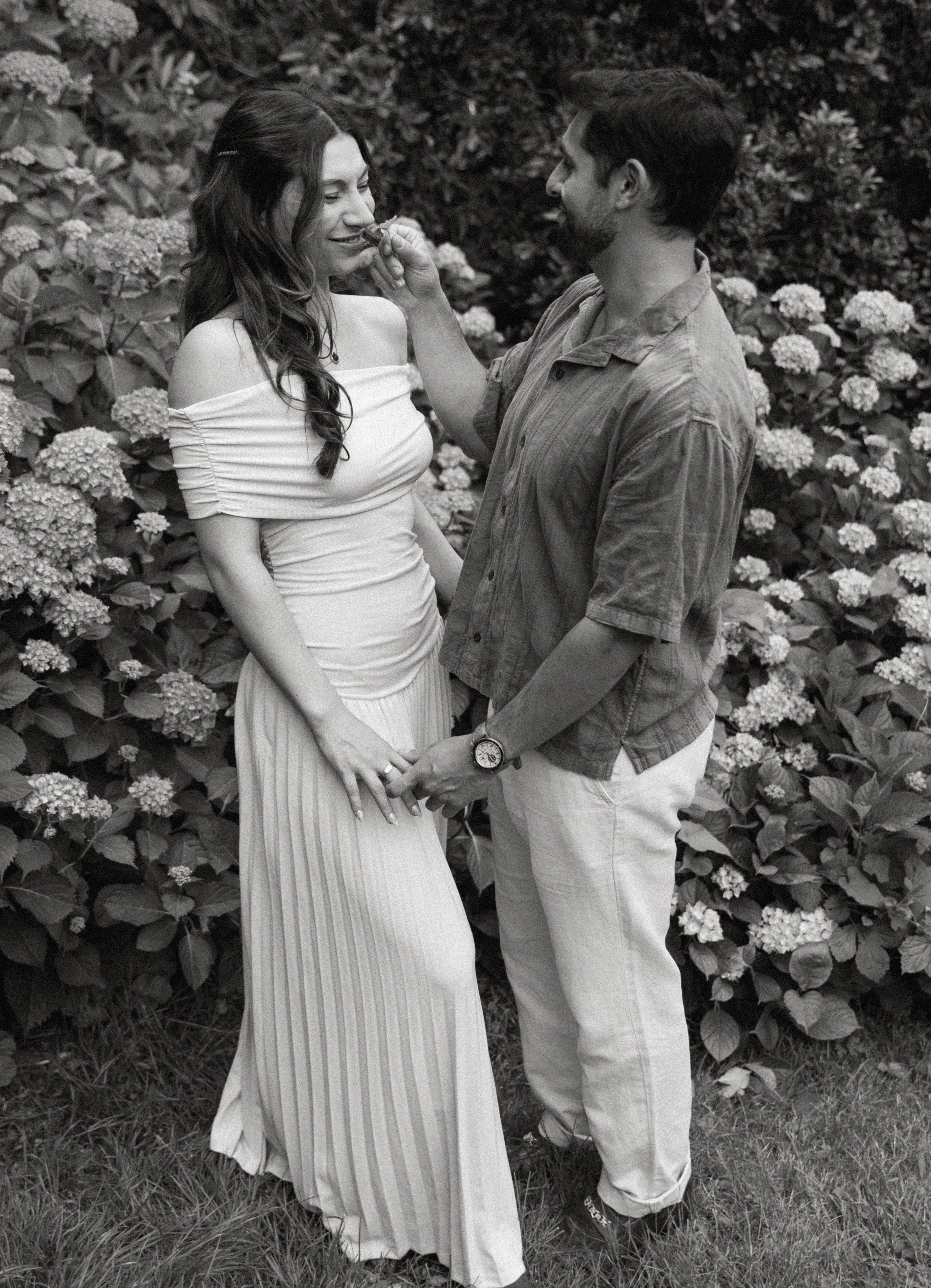 Couple laughing together among hydrangeas + candid joyful moment + Washington Park Arboretum engagement + Seattle Washington photography