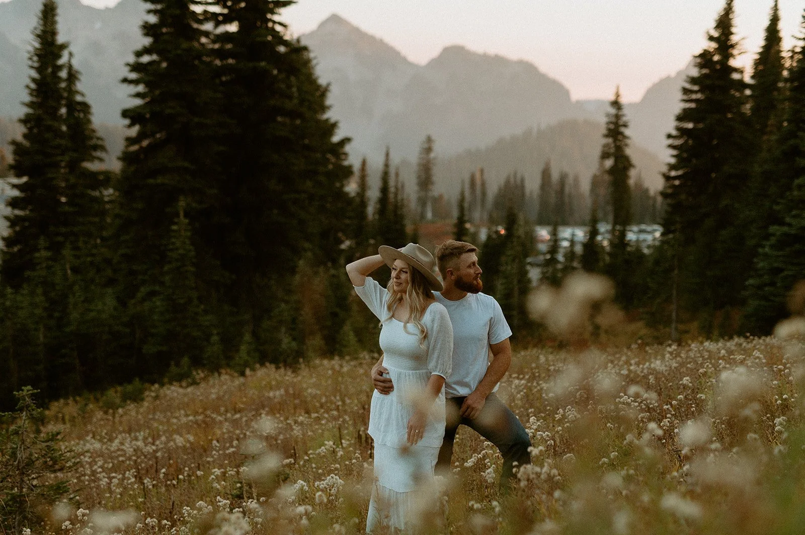 Couple standing in a wildflower field with mountain views at Mount Rainier during golden hour