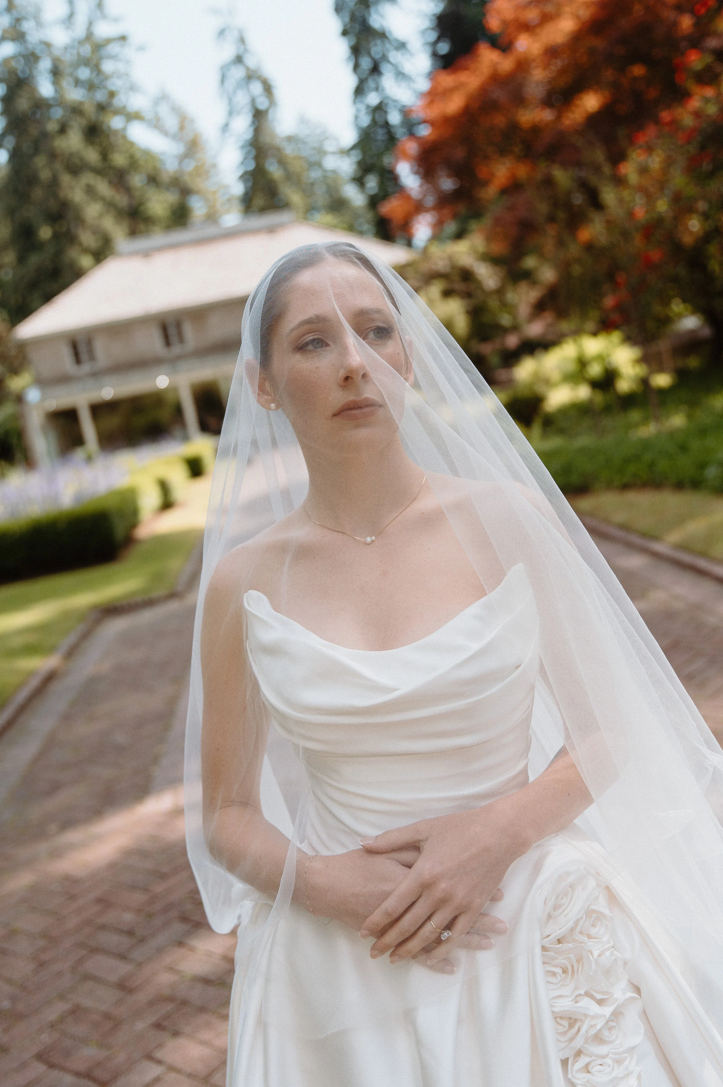 Elegant bridal portrait with cathedral veil at Lakewold Gardens in Lakewood, Washington.