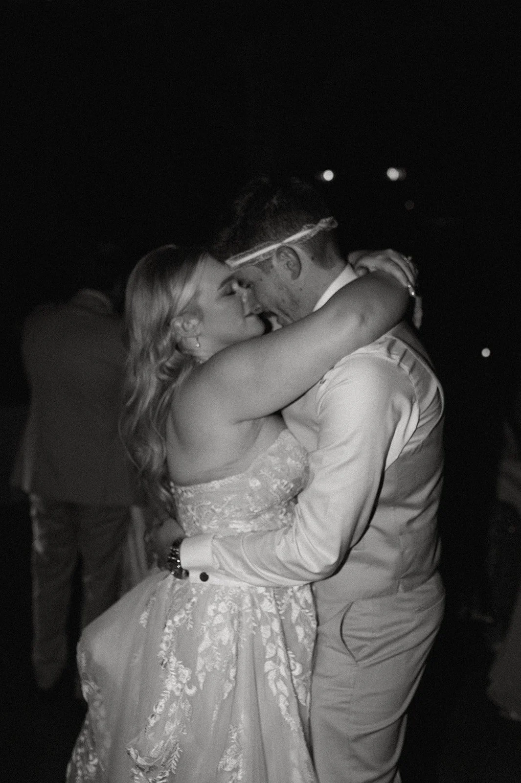 Black and white photo of bride and groom sharing a romantic first dance at wedding reception
