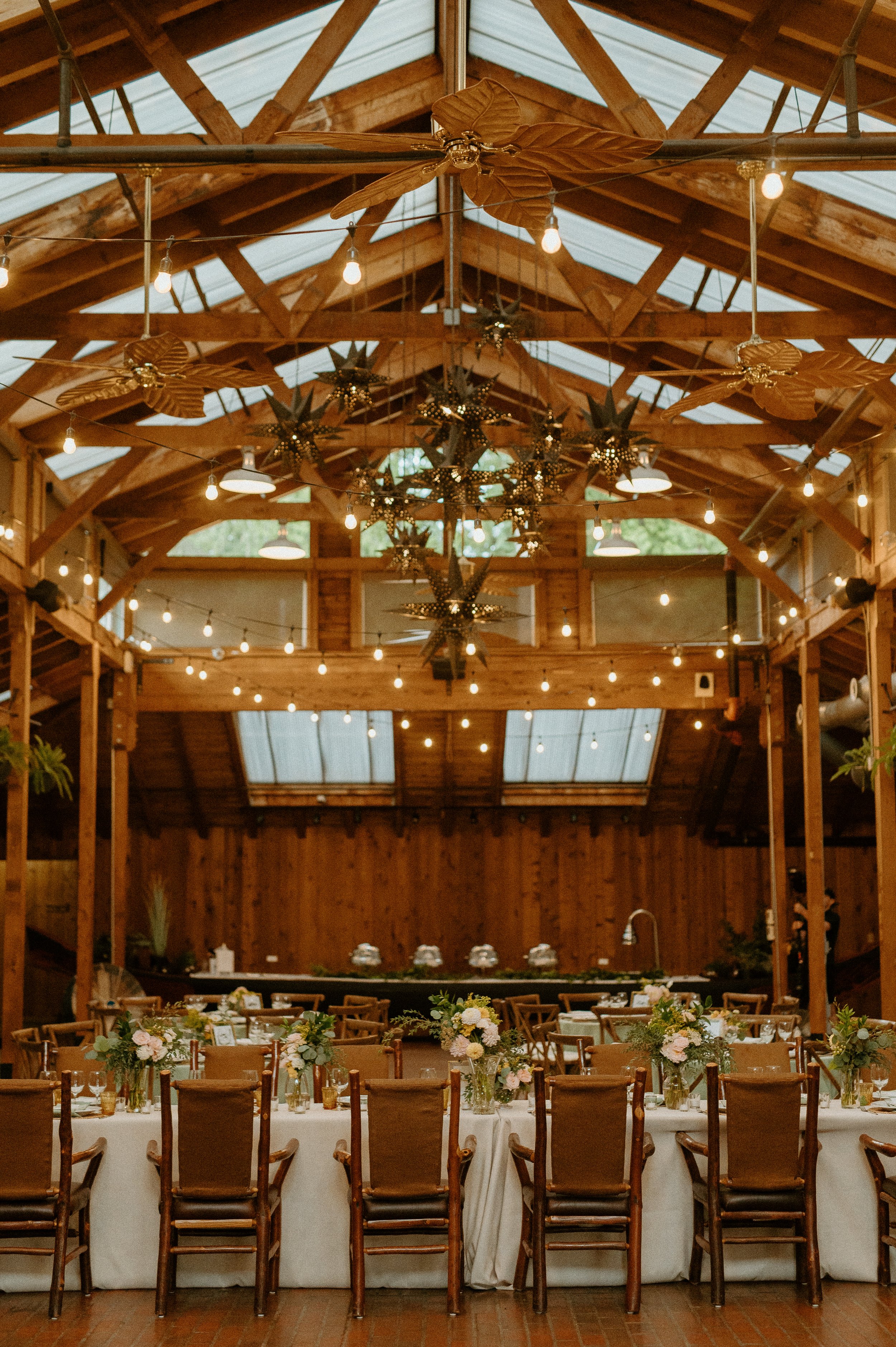 Modern barn wedding reception with hanging star lanterns and warm string lights + rustic wedding venue + Washington barn wedding + PNW wedding