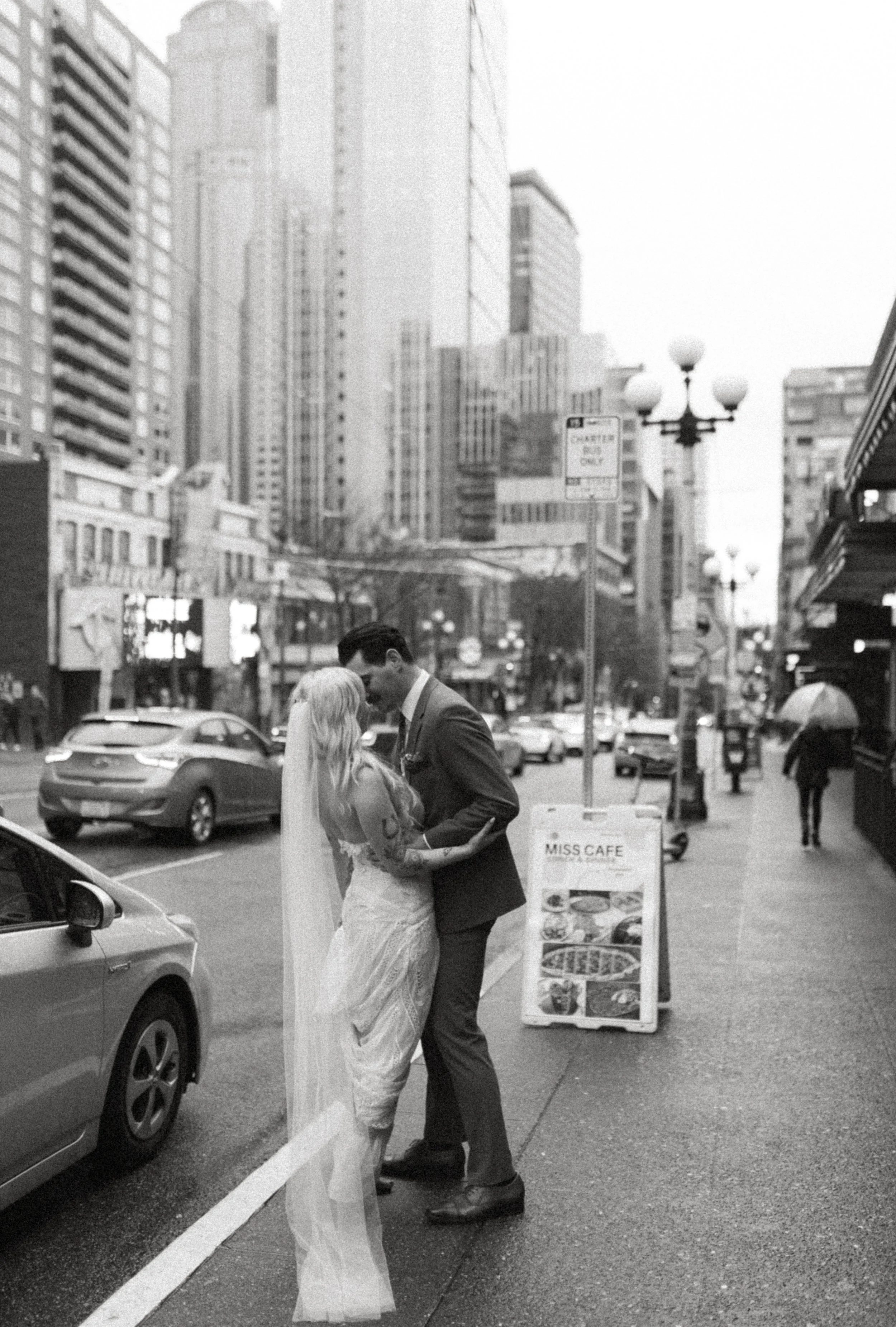 Bride and groom standing in the street during a rainy downtown Seattle elopement