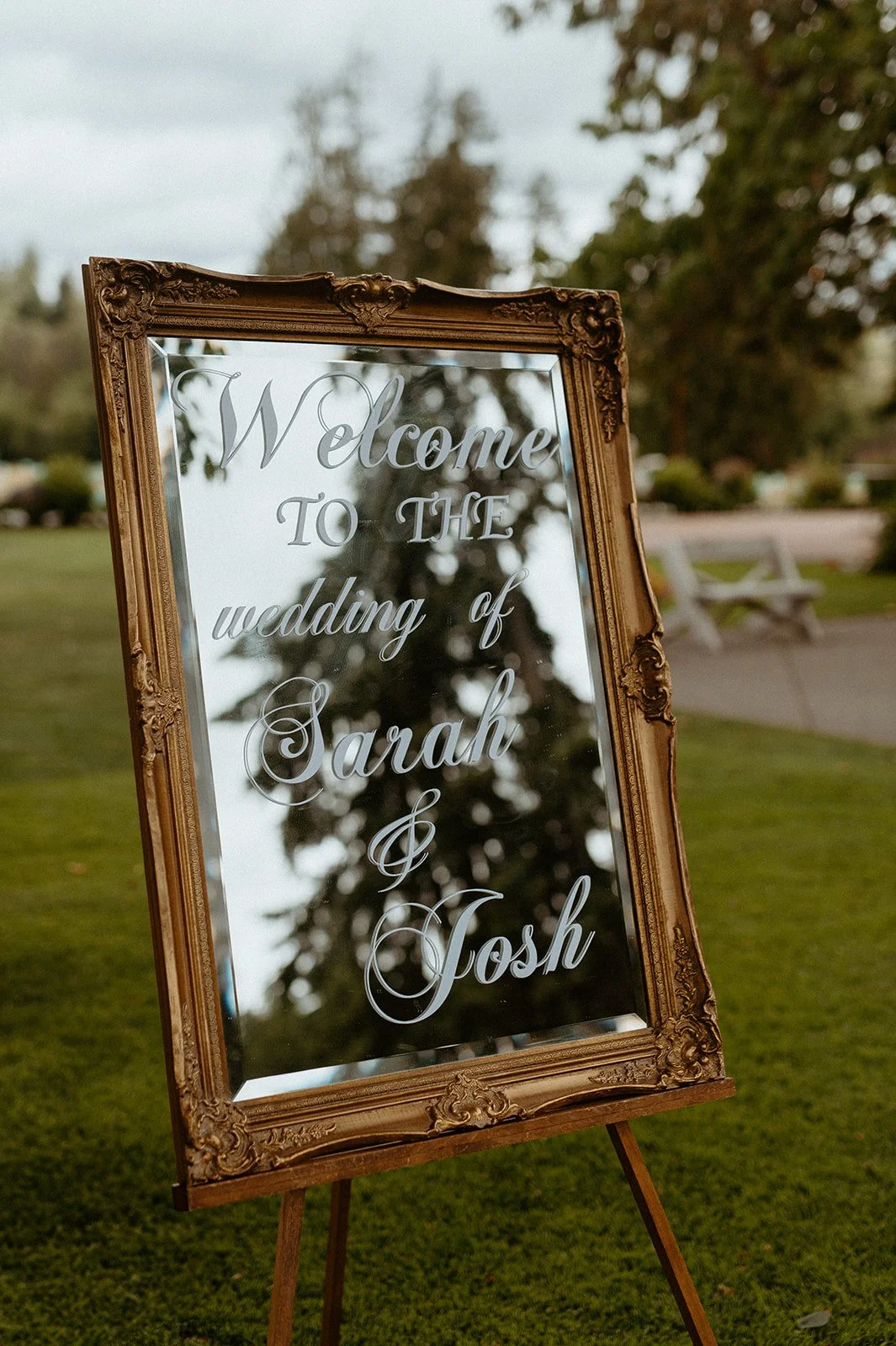 Wedding welcome sign with mirror frame reading Sarah and Josh wedding at outdoor venue