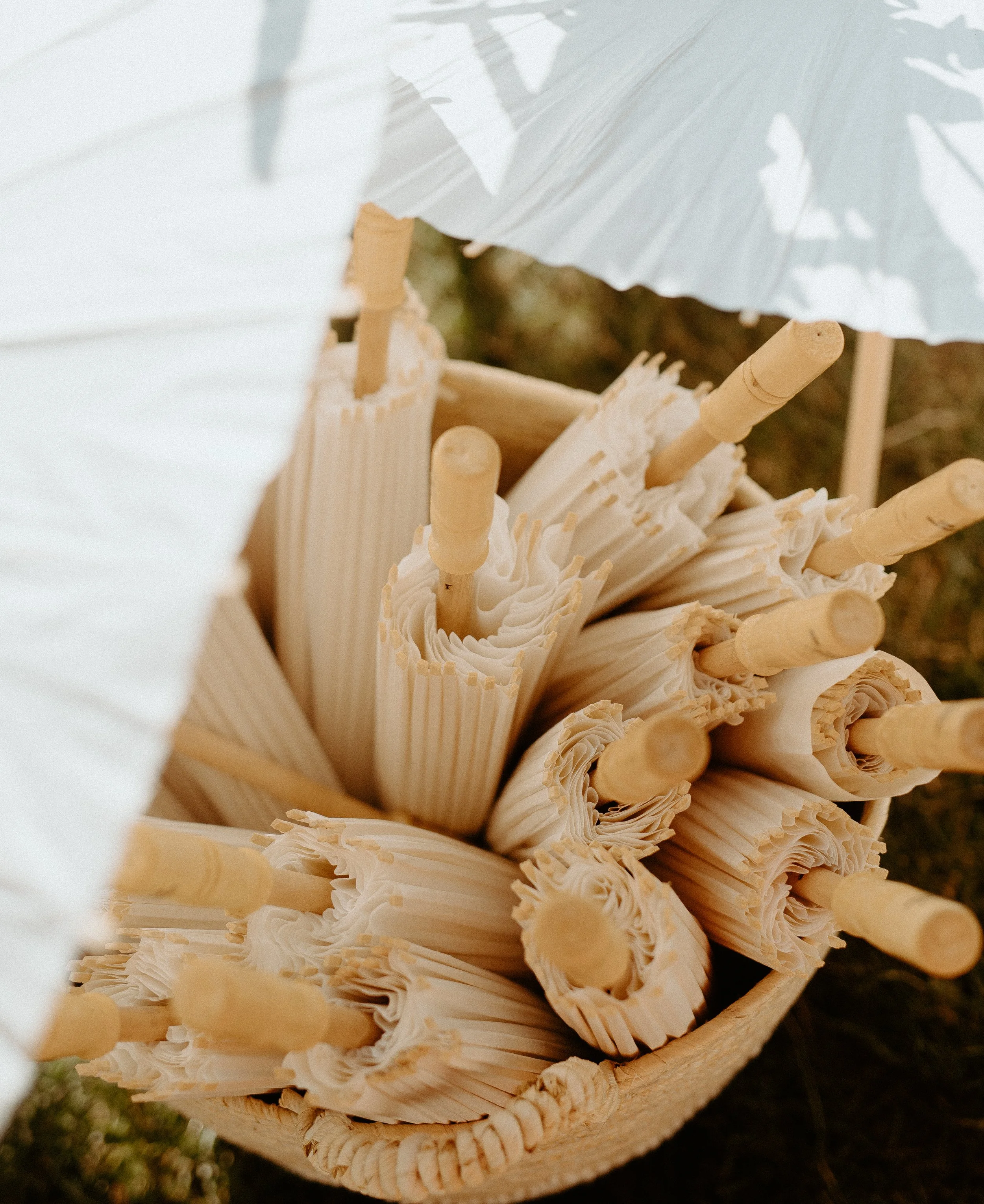 Folded paper parasols in basket for outdoor backyard wedding ceremony in Seattle