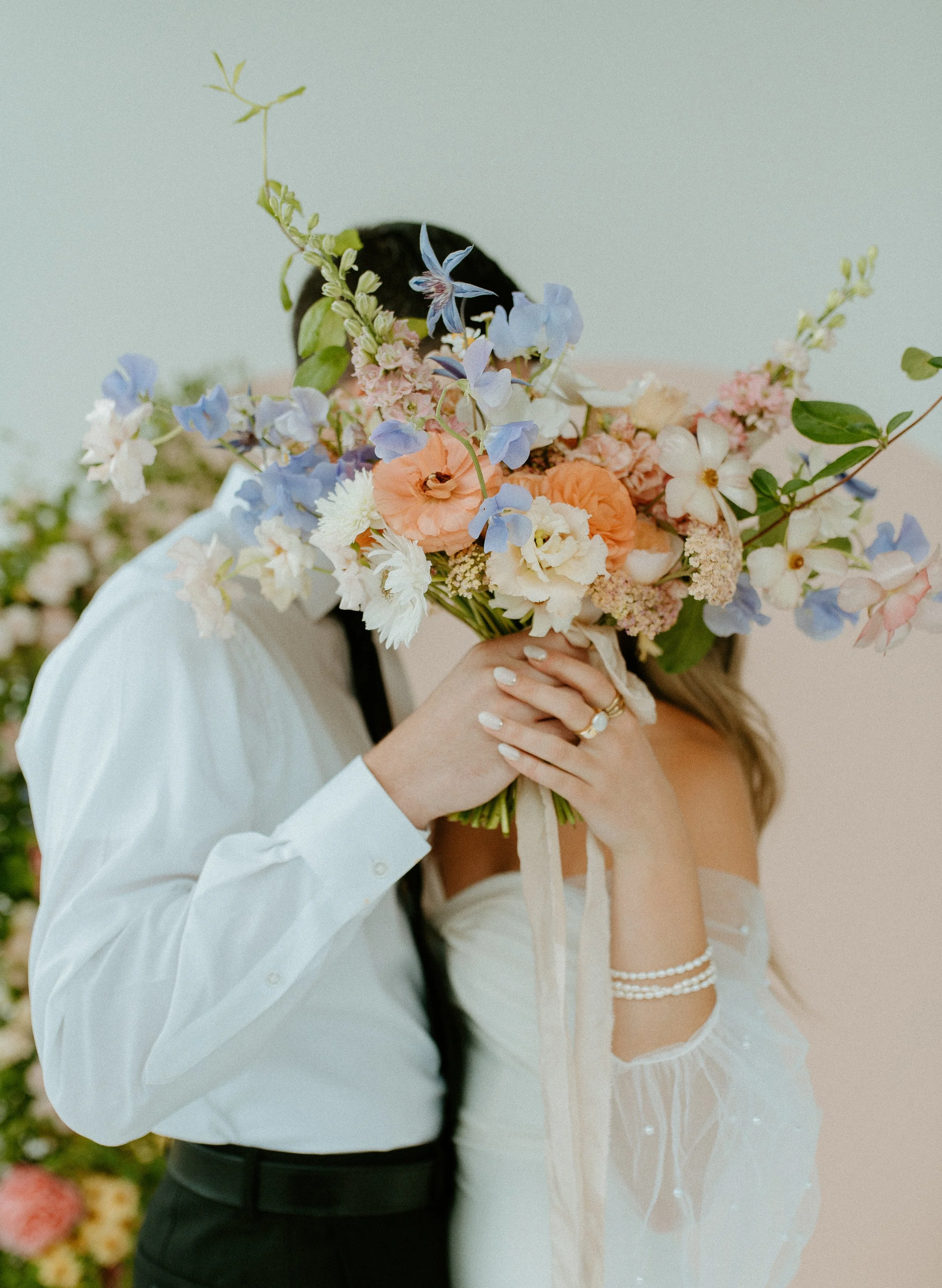 couple kissing behind bouquet during romantic Seattle bridal session