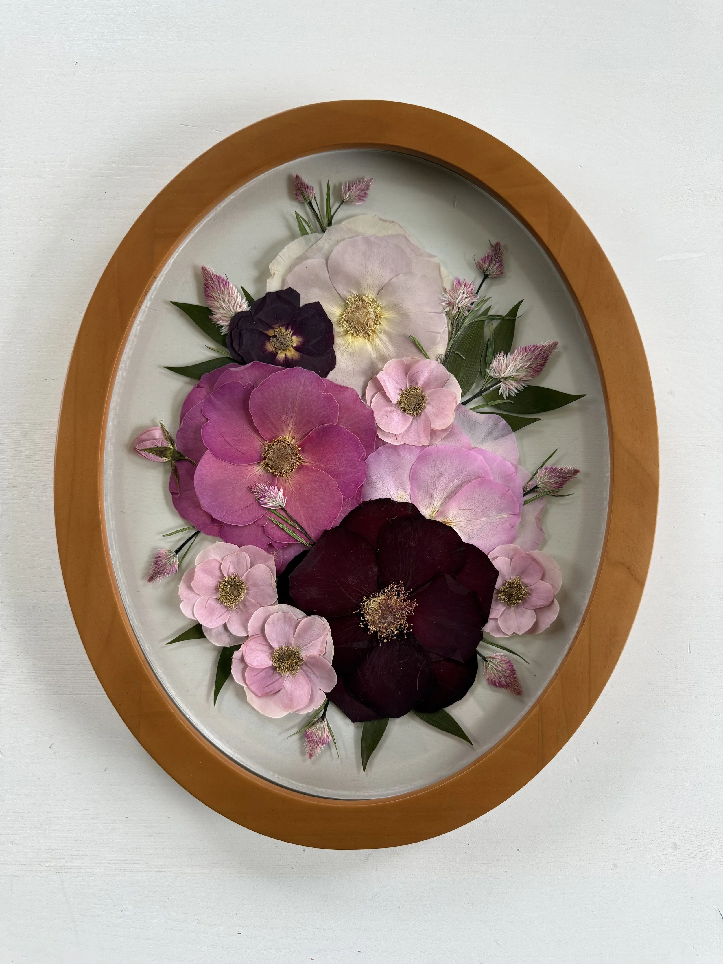 Pressed flowers framed in an oval frame. (Copy)