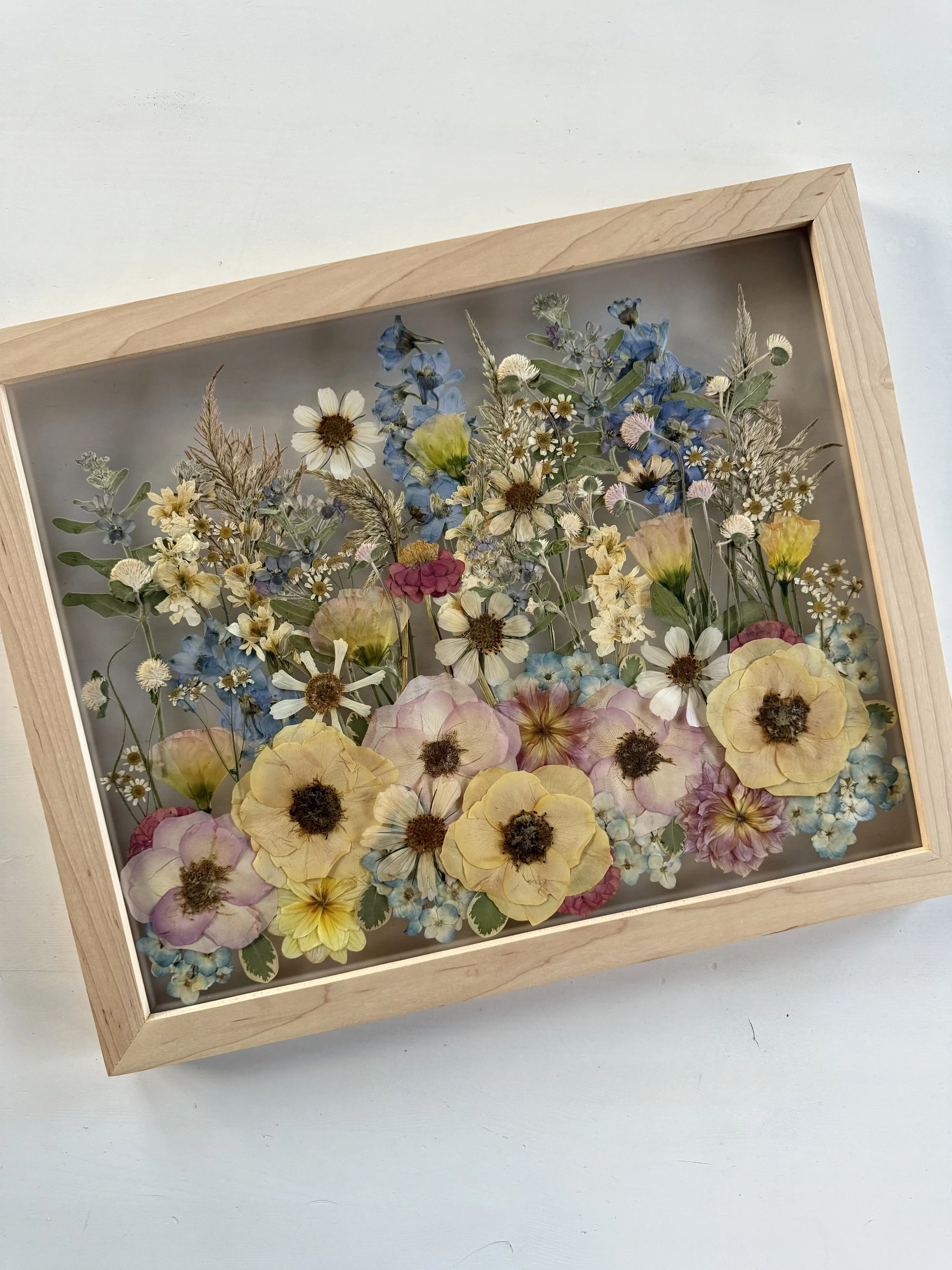 Summer bridal bouquet, pressed and preserved in a frame with a meadow design.