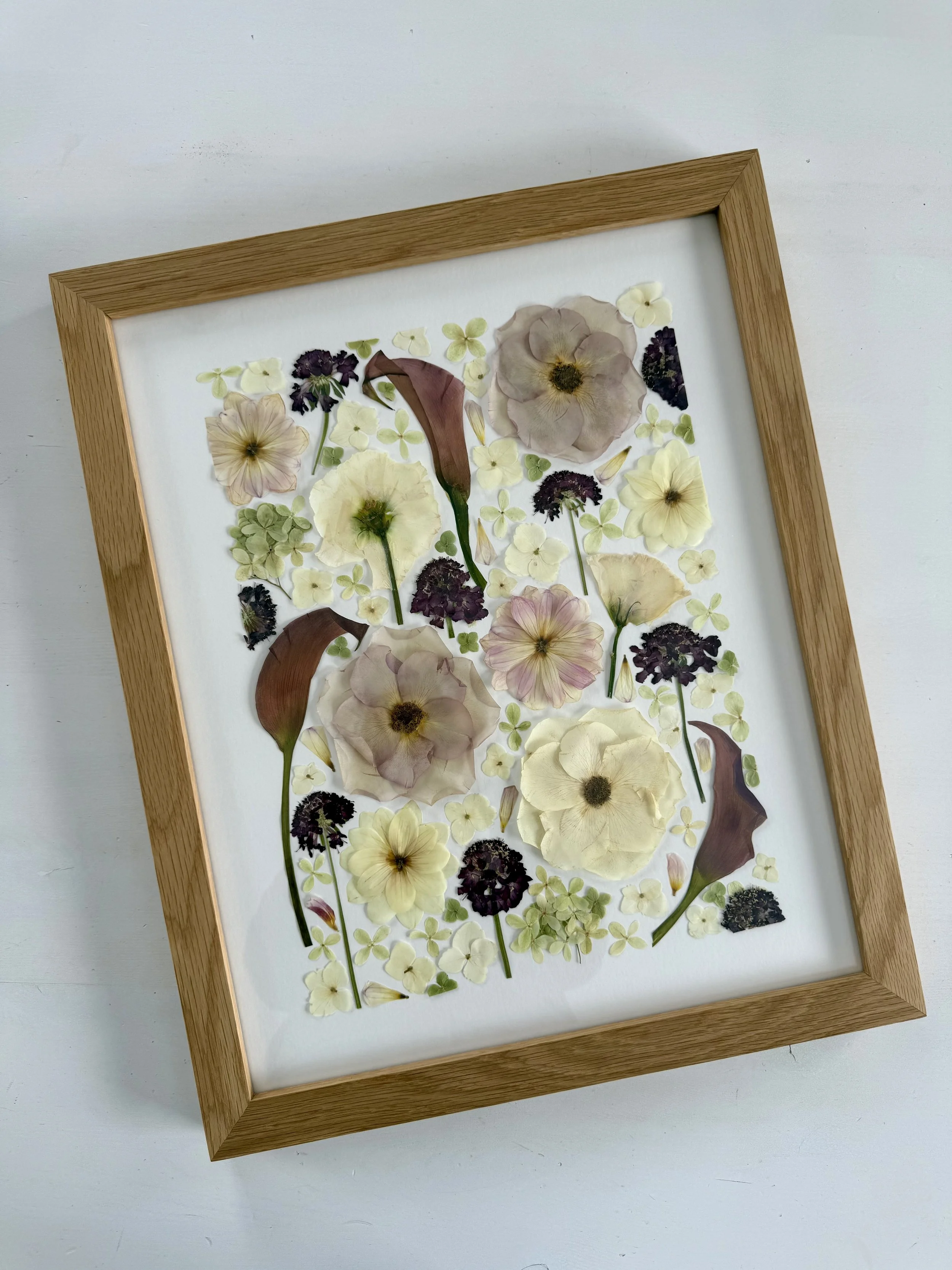 Pressed flowers framed with a botanical, decontructed style.