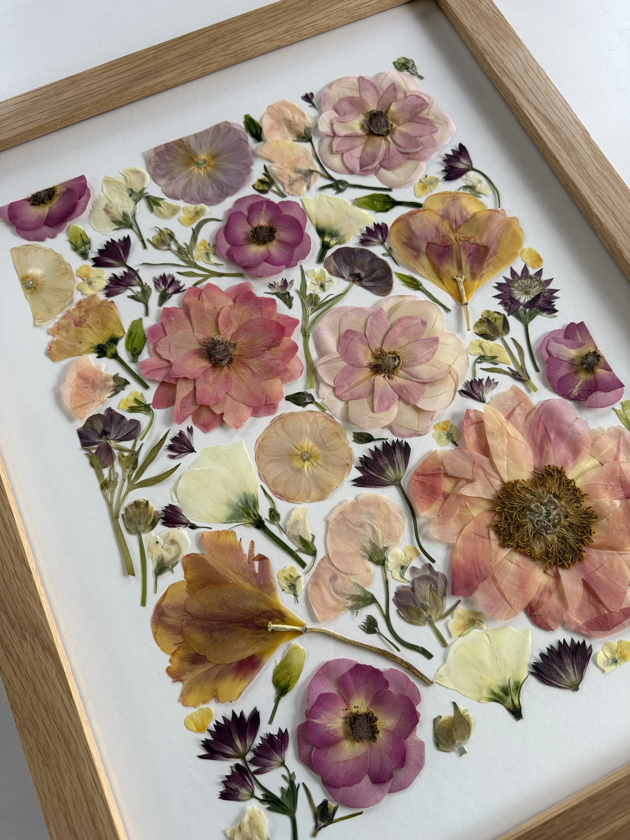 Deconstructed pressed flower design in a frame.